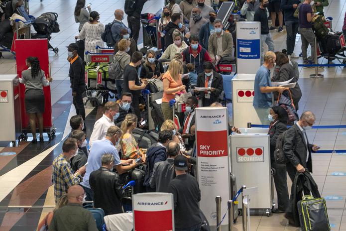 Pasajeros en tránsito en el aeropuerto internacional de Johannesburg, Sudáfrica, comenzaban a apilarse en las terminales tras las cancelaciones de vuelos hacia Europa que comenzaron a entrar en vigor hoy.