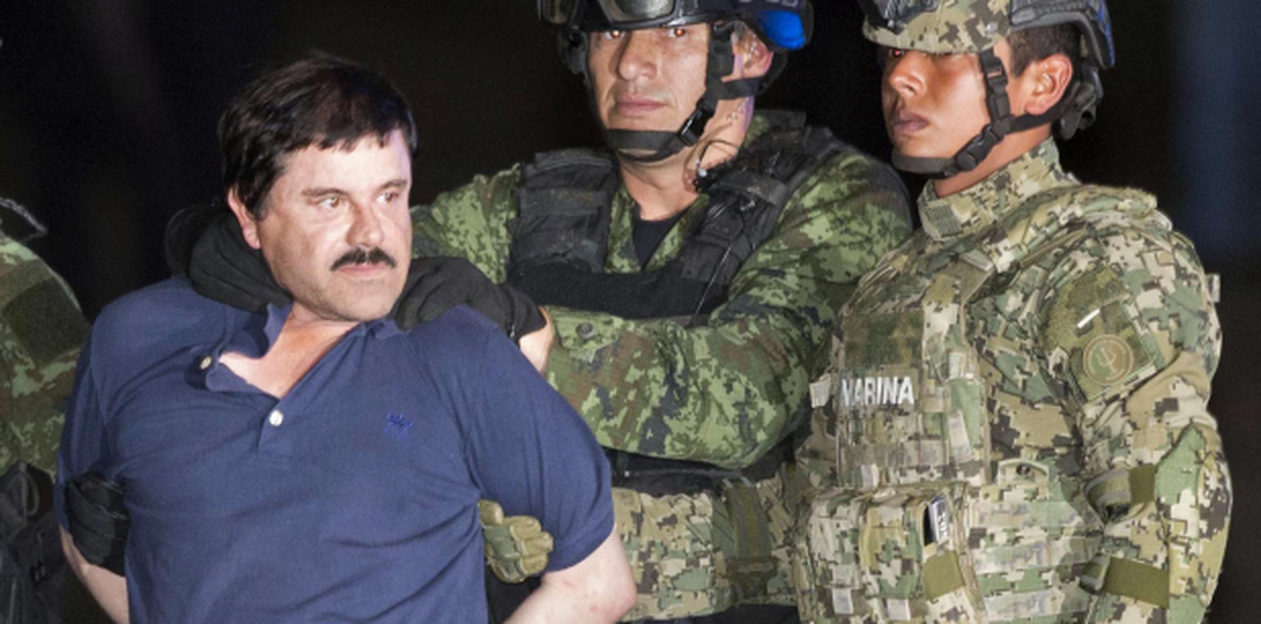 Chapo Guzmán mira a la prensa mientras es escoltado por militares mexicanos en ruta -nuevamente- a una prisión. (AP)