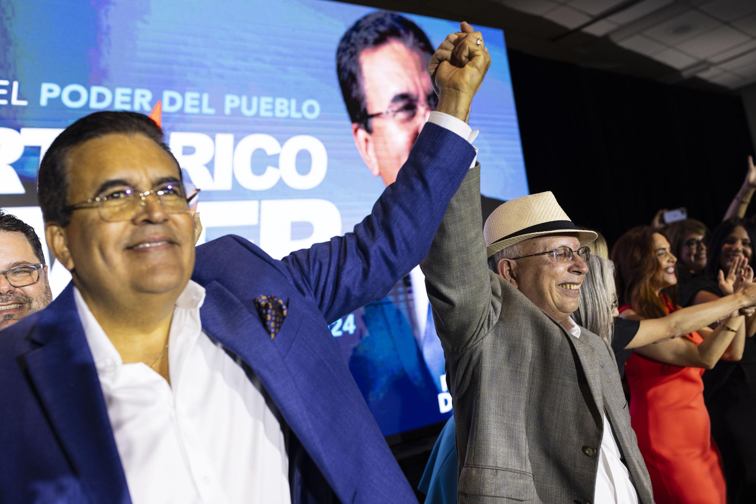 Javier Jiménez (izquierda) y el Dr. César Vázquez, levantan sus manos en señal de victoria durante la actividad del miércoles de Proyecto Dignidad.