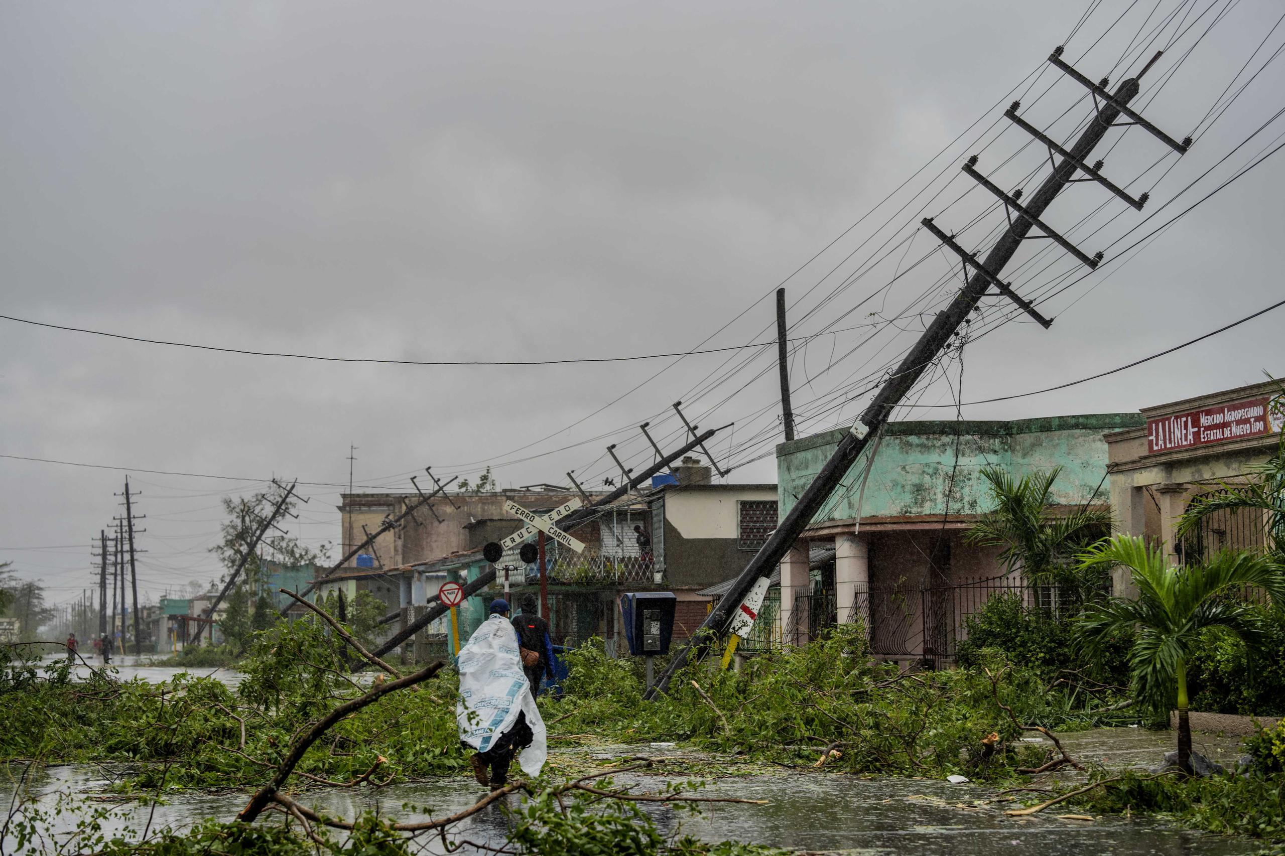 Postes de electricidad caídos y ramas caídas bordean una calle después de que el huracán Ian azotara Pinar del Río, Cuba, el martes 27 de septiembre de 2022. (AP Foto/Ramón Espinosa)