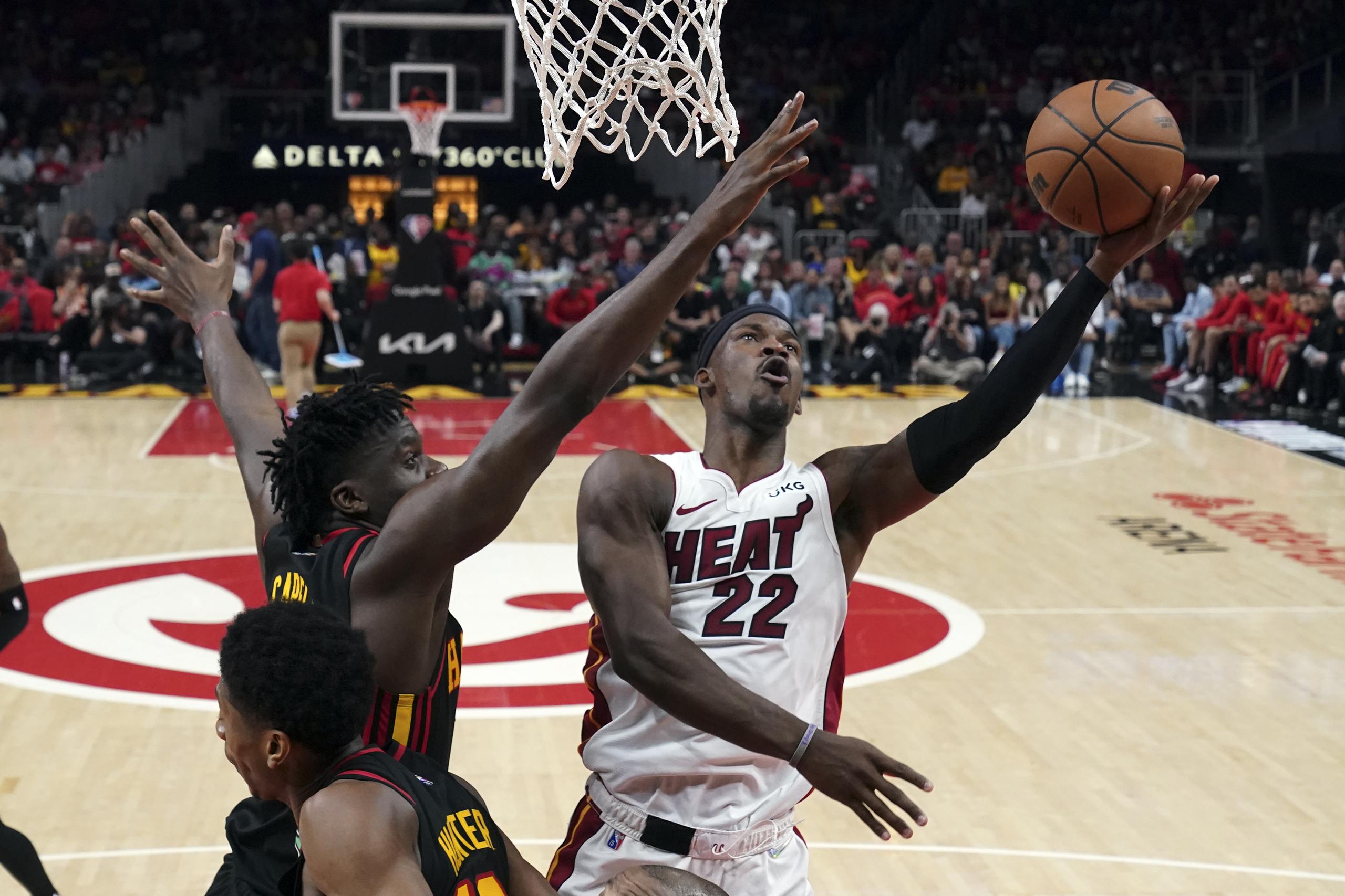 El alero del Heat de Miami Jimmy Butler lanza el balón sobre el pívot de los Hawks de Atlanta Clint Capela en el juego 4 de la serie de primera ronda de la postemporada.