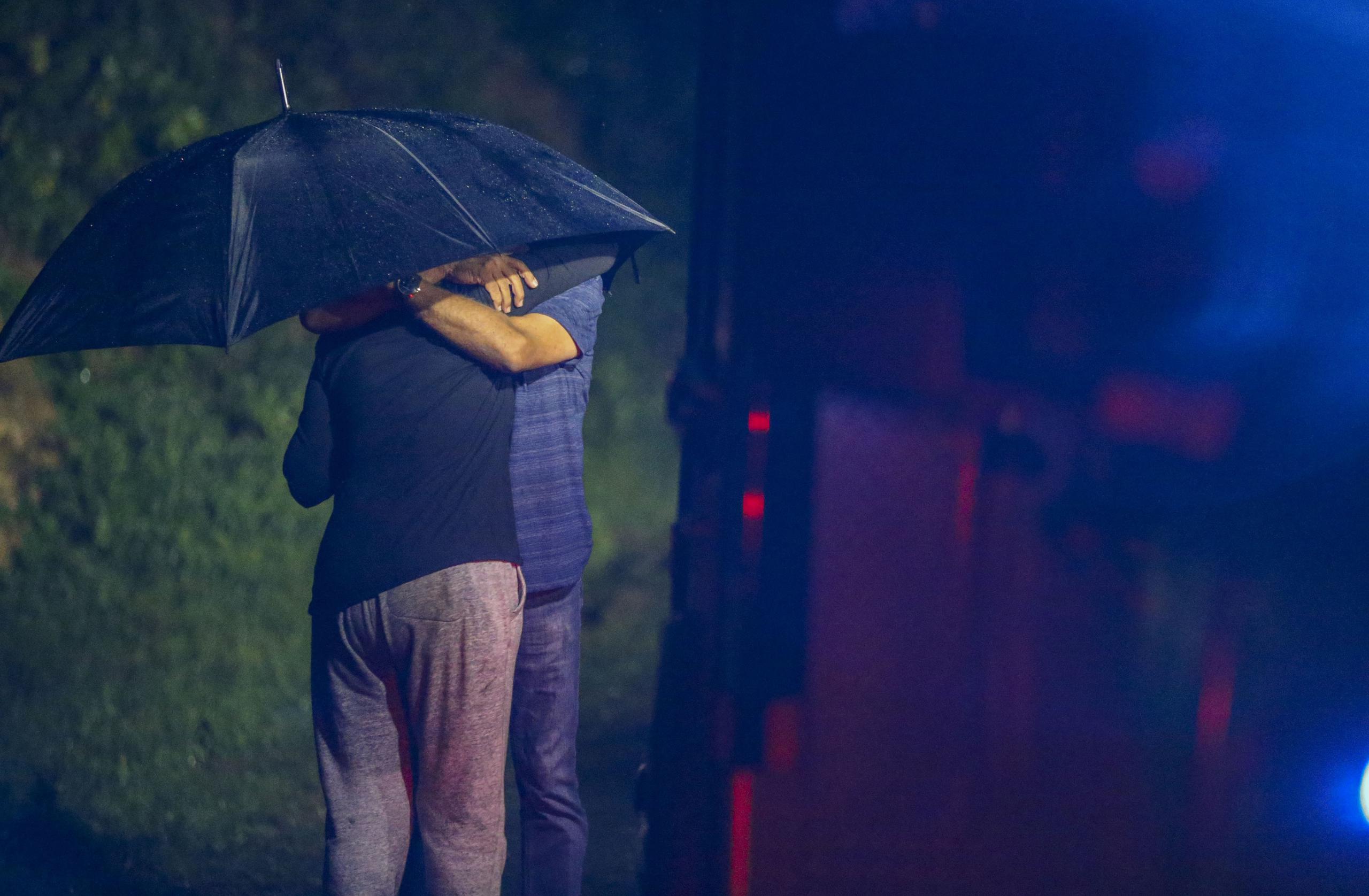 Una persona se abraza a otra cerca del área donde ocurrieron los asesinatos.