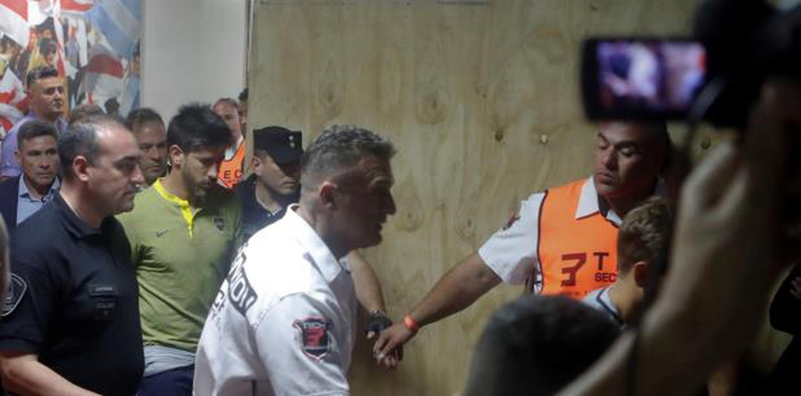El jugador de Boca Juniors Pablo Pérez (c) sale acompañado por médicos luego que el autobús del equipo fuera atacado por aficionados de River Plate. (EFE)
