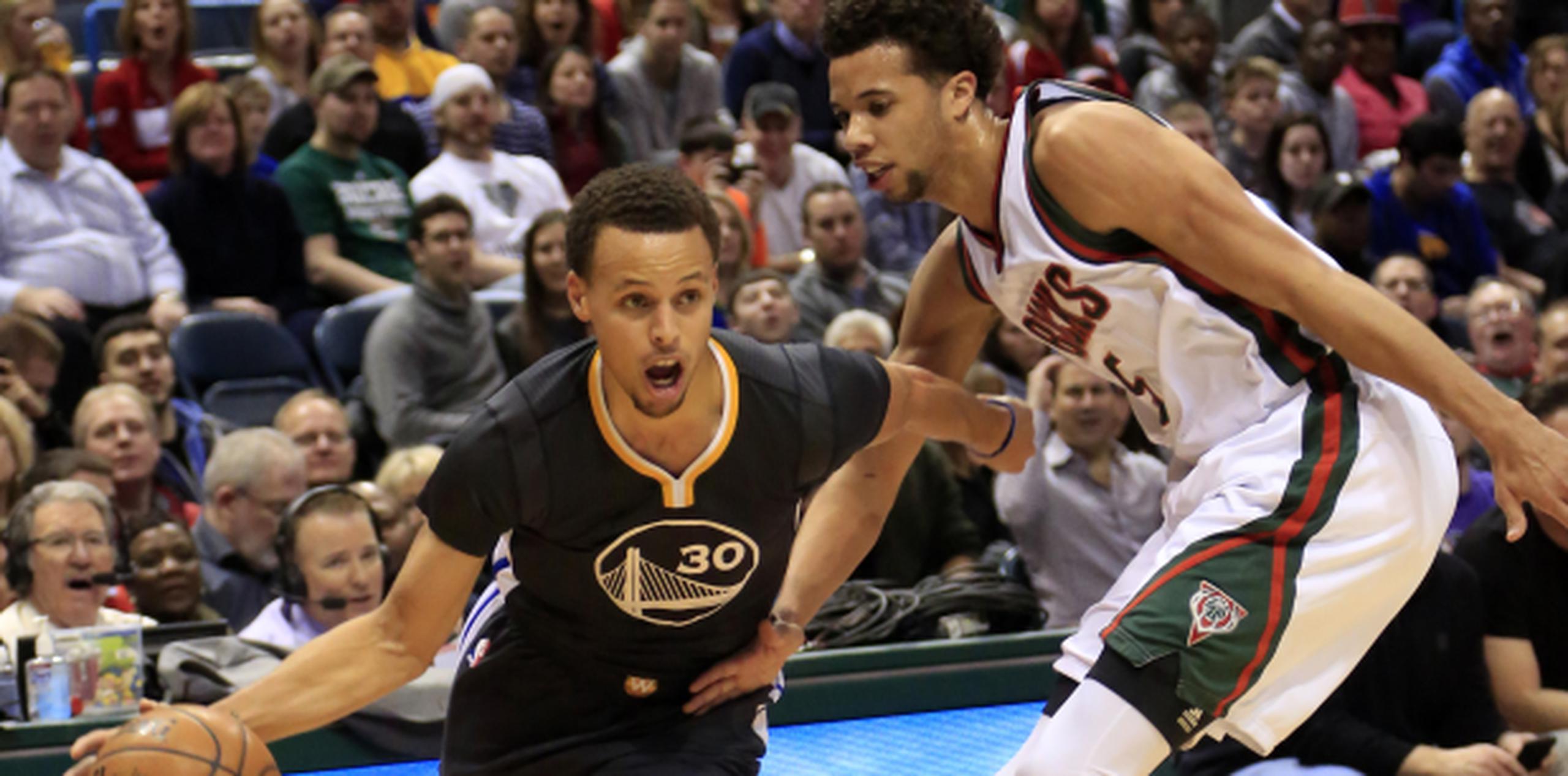 Stephen Curry (izquierda) de los Warriors anotó 25 puntos en el juego de anoche contra los Bucks de Milwaukee. (AP/Darren Hauck)