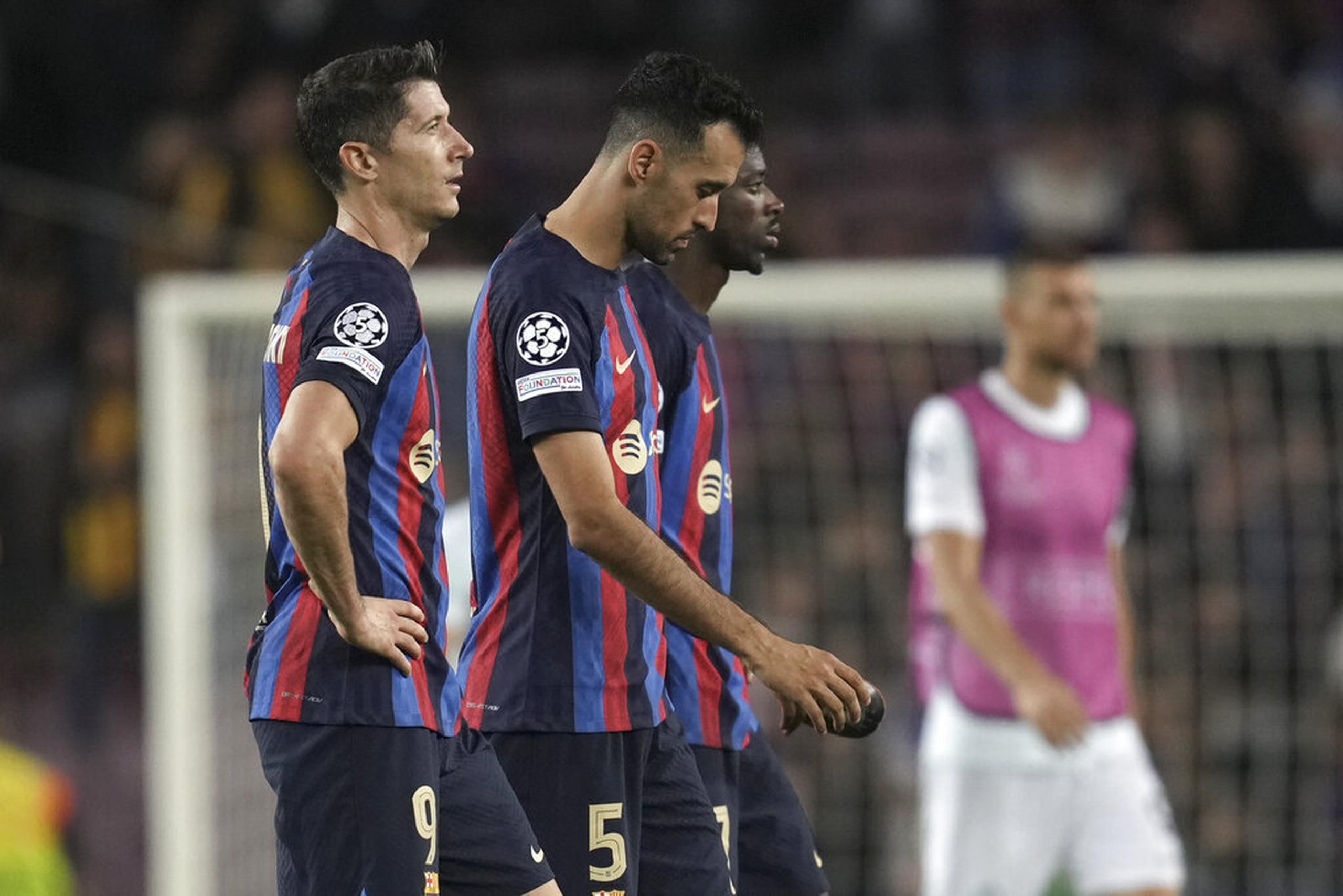 De izquierda a derecha, Robert Lewandowski, Sergio Busquets y Ousmane Dembélé, del Barcelona, abandonan la cancha luego del partido por la Liga de Campeones ante el Inter.
