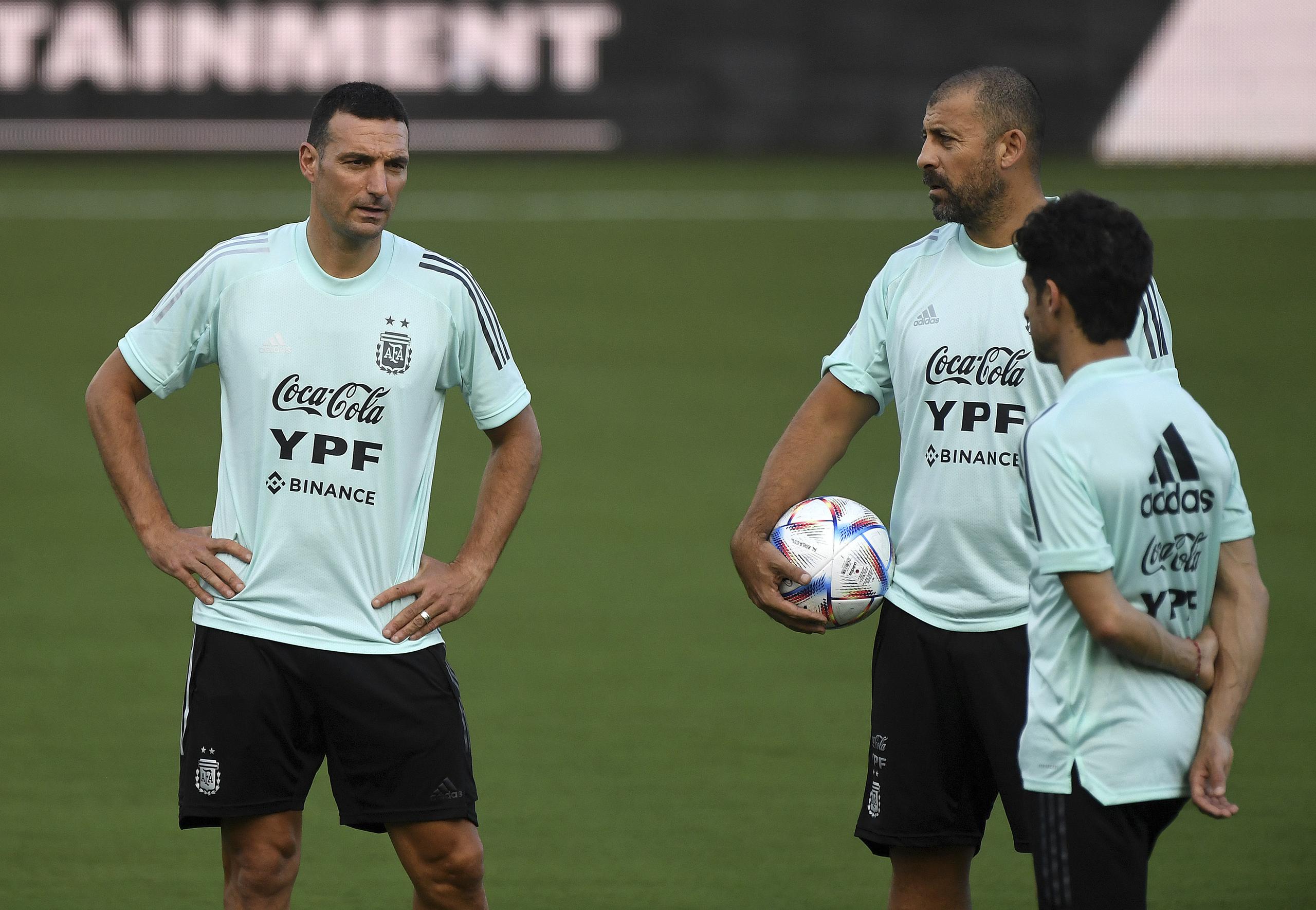 El técnico de Argentina Lionel Scaloni (izquierda) charla con sus colaboradores Walter Samuel y Pablo Aimar (de espalda), durante un entrenamiento, el 22 de septiembre de 2022, en Fort Laudardele.