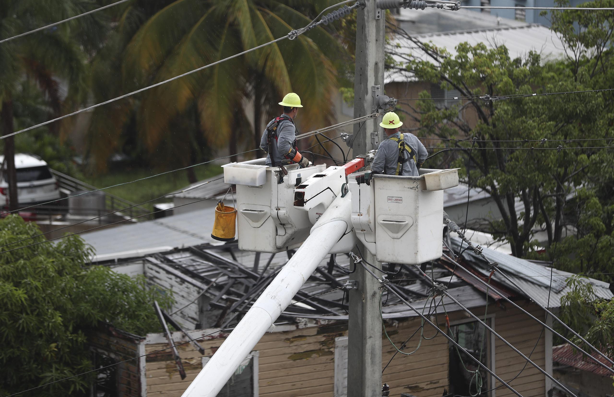 Una brigada de la Autoridad de Energía Eléctrica trabaja en la calle del Parque en Santurce luego del paso de la tormenta Isaías
