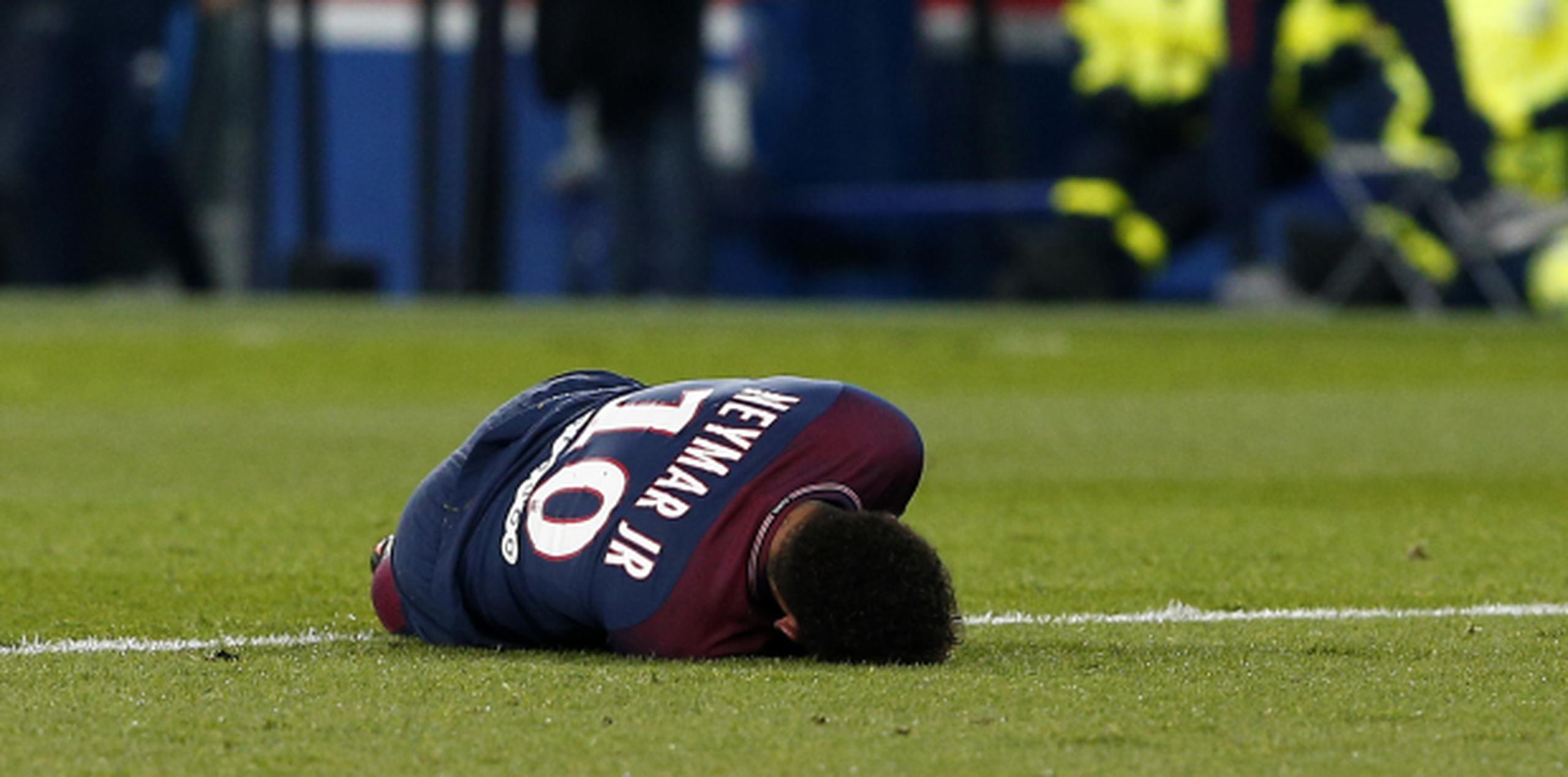 El delantero brasileño Neymar se retuerce del dolor tras lesionarse en el partido contra Marsella por la liga francesa, el domingo. (AP)