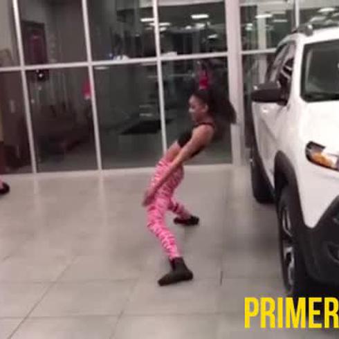 Mujer baila limbo bajo un carro