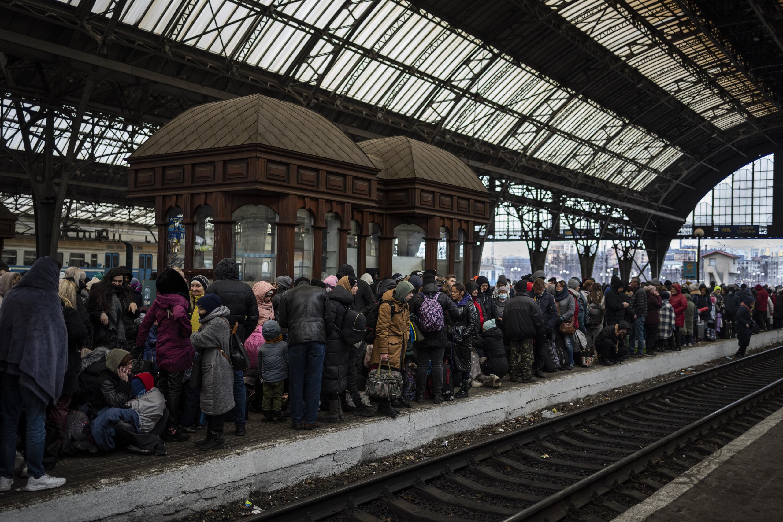 Los pasajeros esperan en el andén dentro de la estación de tren de Lviv.