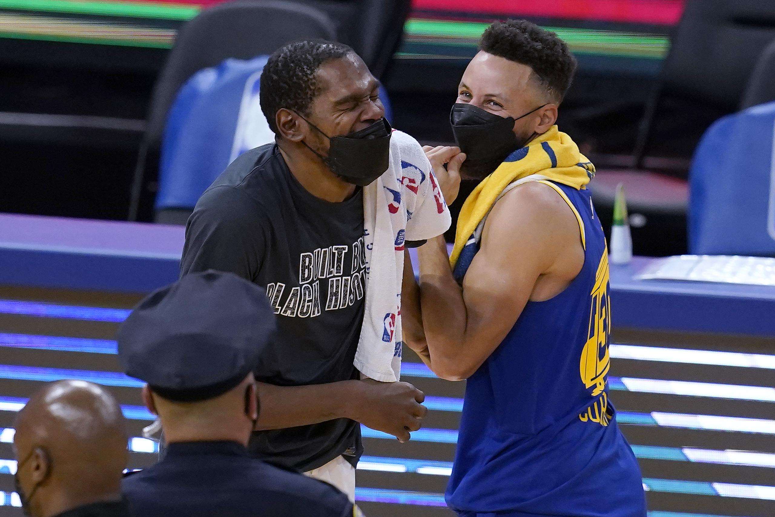 Los excompañeros Kevin Durant (izquierda) y Stephen Curry se confunden en un abrazo previo al partido entre los Nets de Brooklyn y los Warriors de Golden State.
