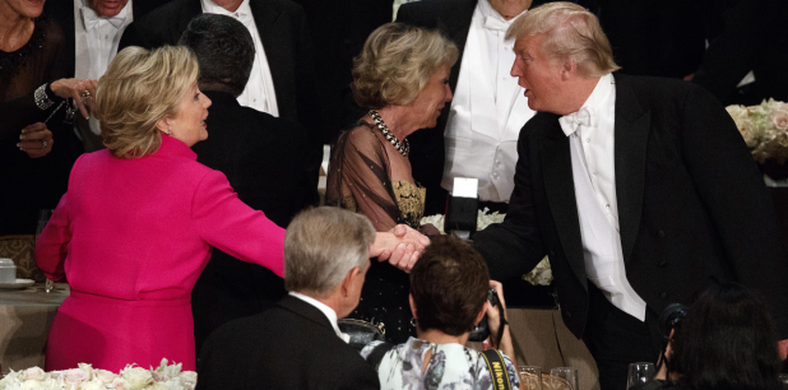 Clinton y Trump se dieron la mano en la cena, algo que no hicieron en los debates. (Prensa Asociada)