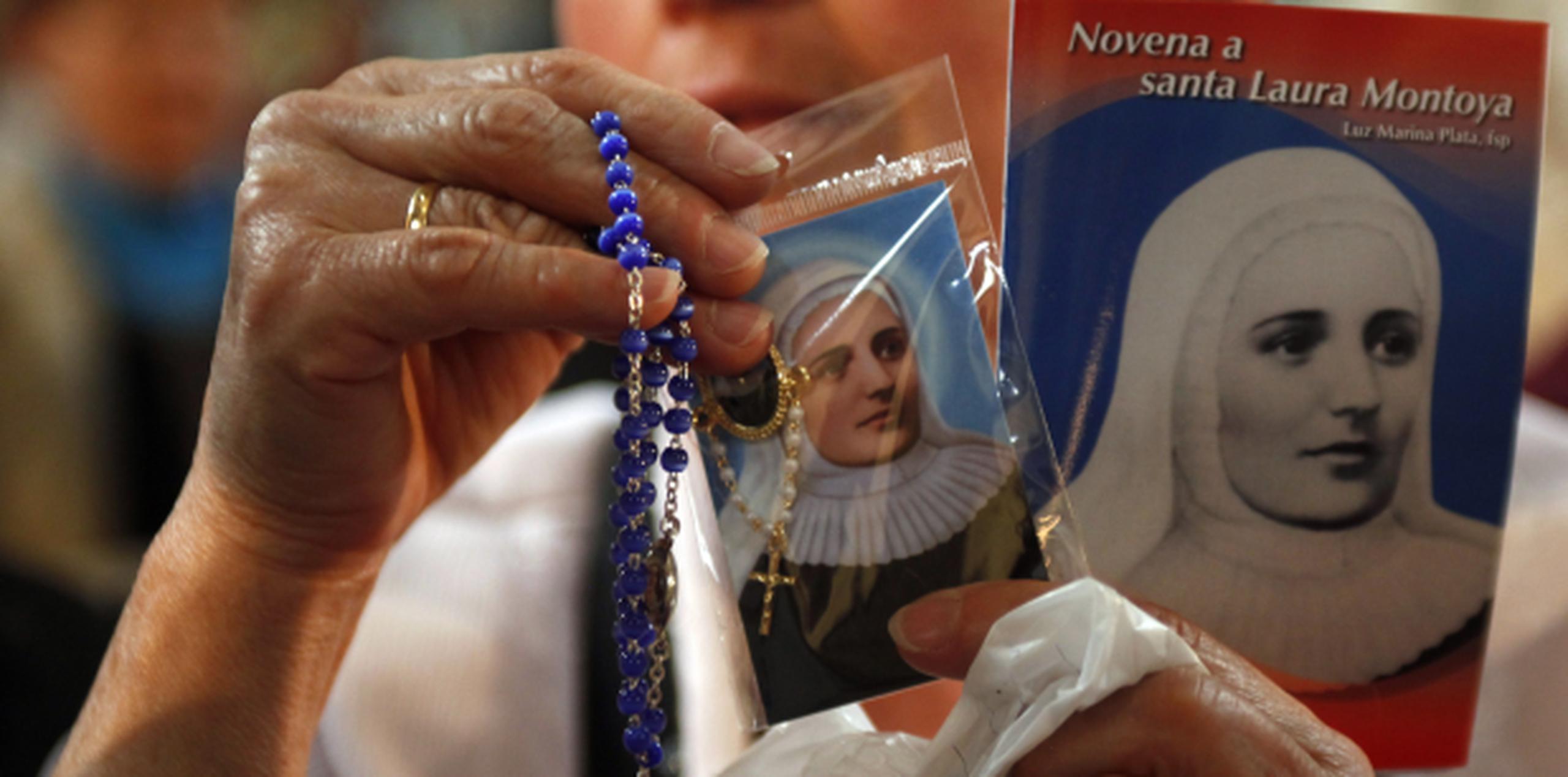 Una colombiana muestra artículos religiosos dedicados a la devoción hacia la santa Laura Montoya. (AP)