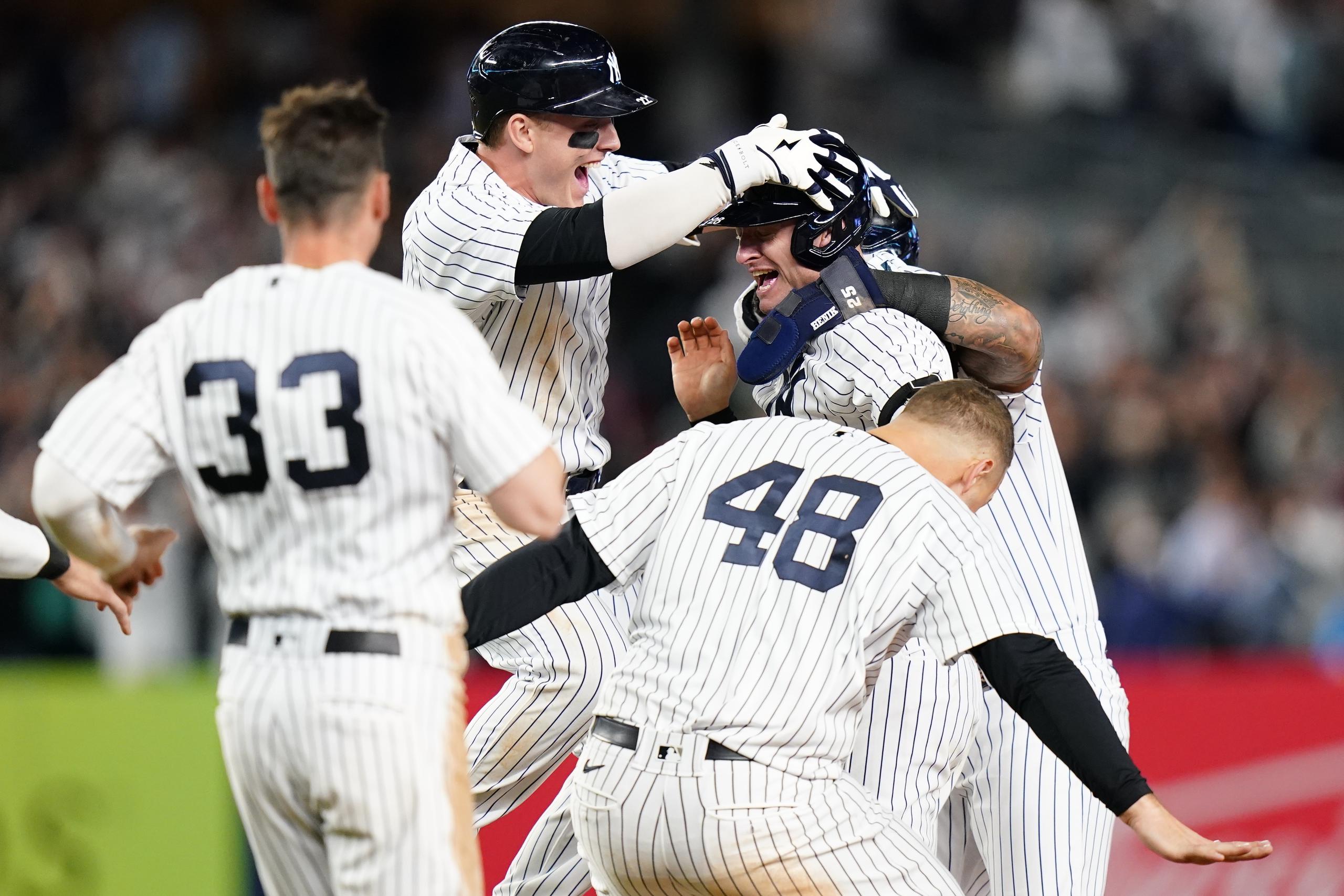 Josh Donaldson, de los Yankees, es alcanzado por sus compañeros de equipo en medio del festejo luego de que Donaldson sacudiera el inatrapable que les dio la victoria 5-4 ante Boston y les diera su boleto a la postemporada.
