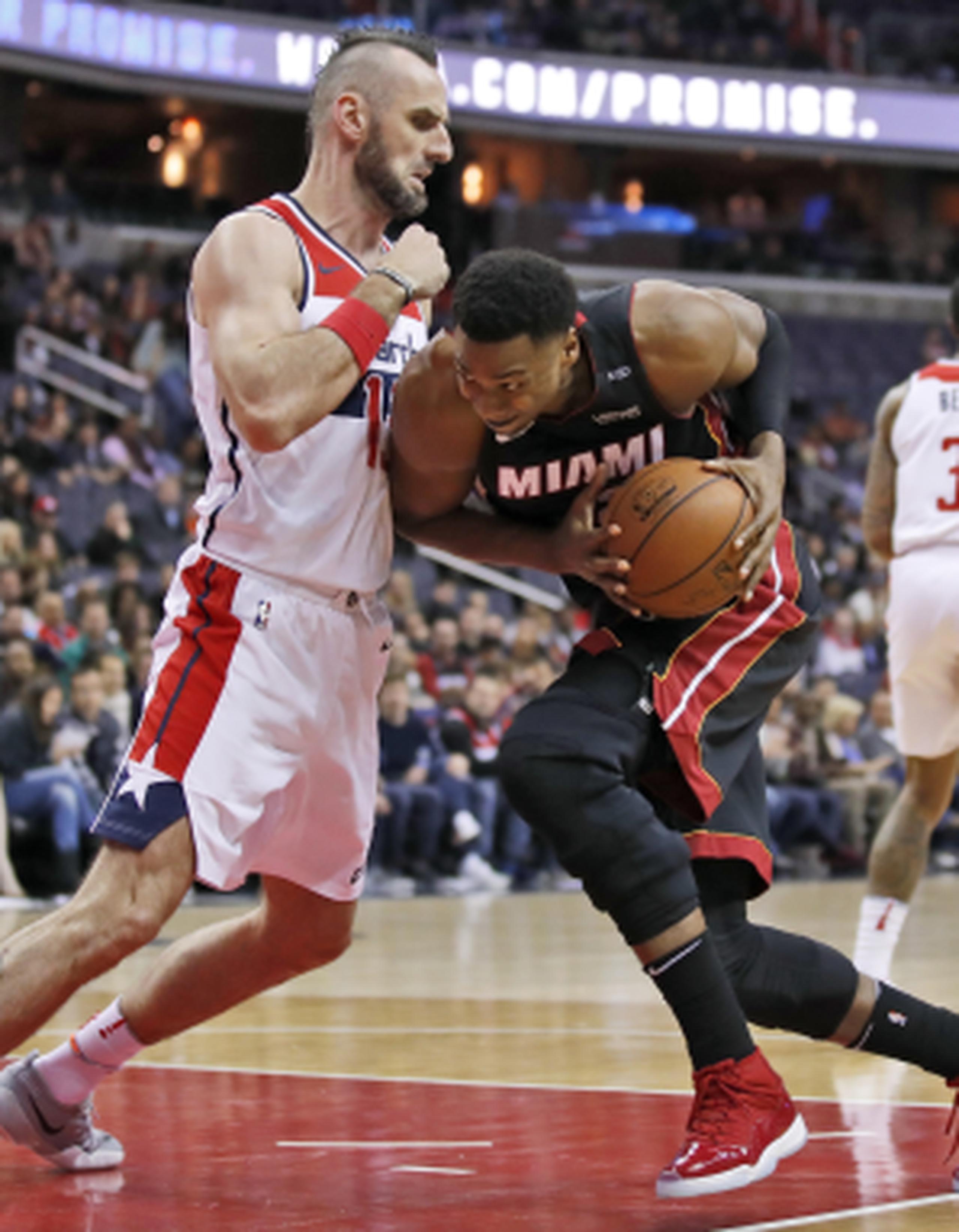 El pívot del Heat de Miami, Hassan Whiteside, es defendido por el pívot de los Wizards de Washington, Marcin Gortat, en la primera mitad del juego del martes. (AP)