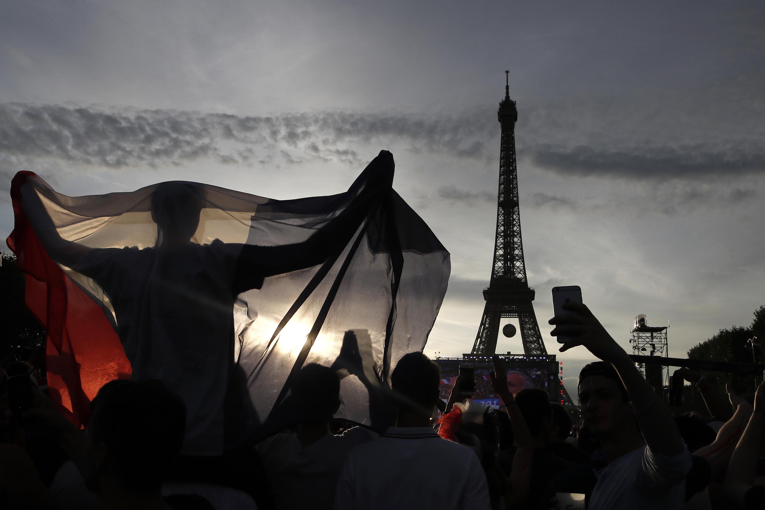 En esta imagen de archivo, un aficionado despliega una bandera de Francia en una zona habilitada para hinchas en las inmediaciones de la Torre Eiffel, durante un juego de la Eurocopa 2016 entre Portugal y Francia, el 10 de julio de 2016 en París.