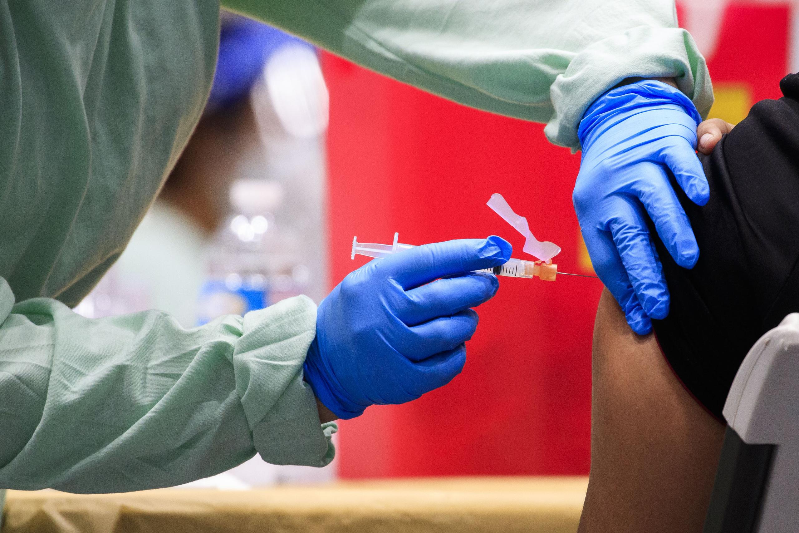 Personal médico inyecta a una persona la vacuna contra el COVID-19.
