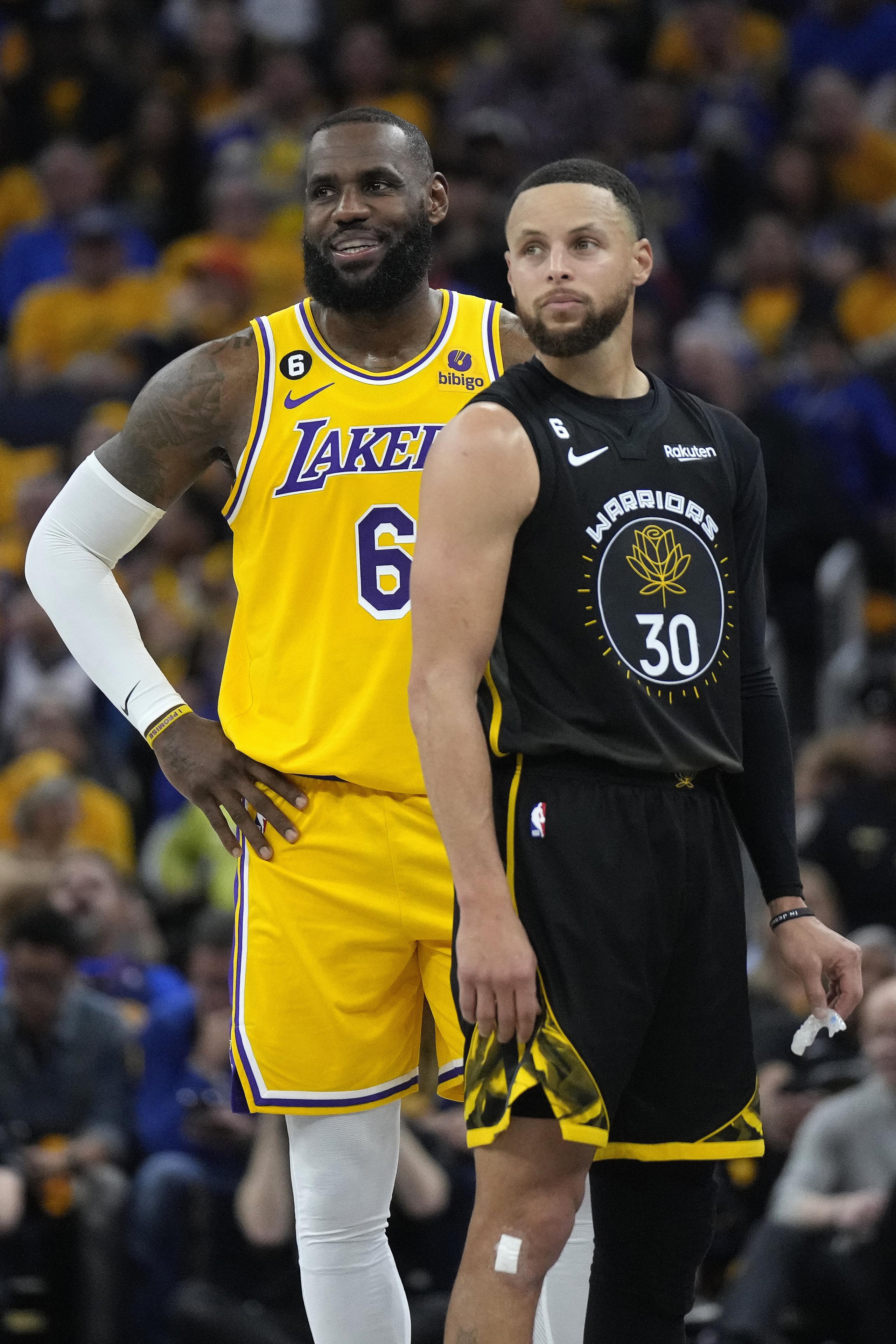 El jugador de los Lakers de Los Ángeles LeBron James (6) y el jugador de los Warriors de Golden State Stephen Curry (30) se ven parados en la primera mitad de un juego de semifinales de la Conferencia Oeste de la NBA, el martes 2 de mayo de 2023 en San Francisco. (AP Foto/Jeff Chiu)