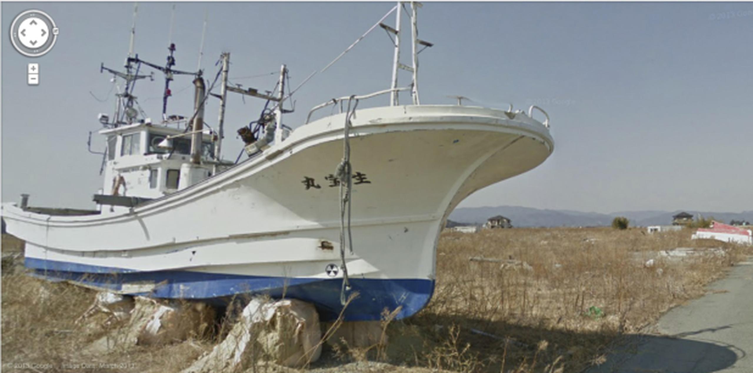 Un barco permanece varado sobre una franja de tierra aplanada por el maremoto que recorrió la costa. (AP/Google)