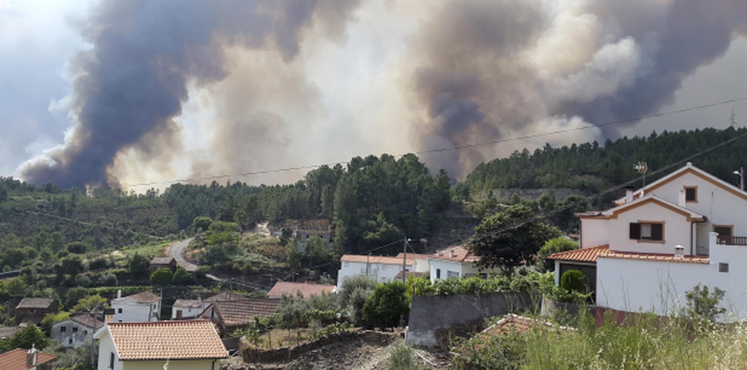 Las densas columnas de humo y las llamas han forzado la evacuación de decenas de localidades en el centro de Portugal. (EFE/Carlos García)