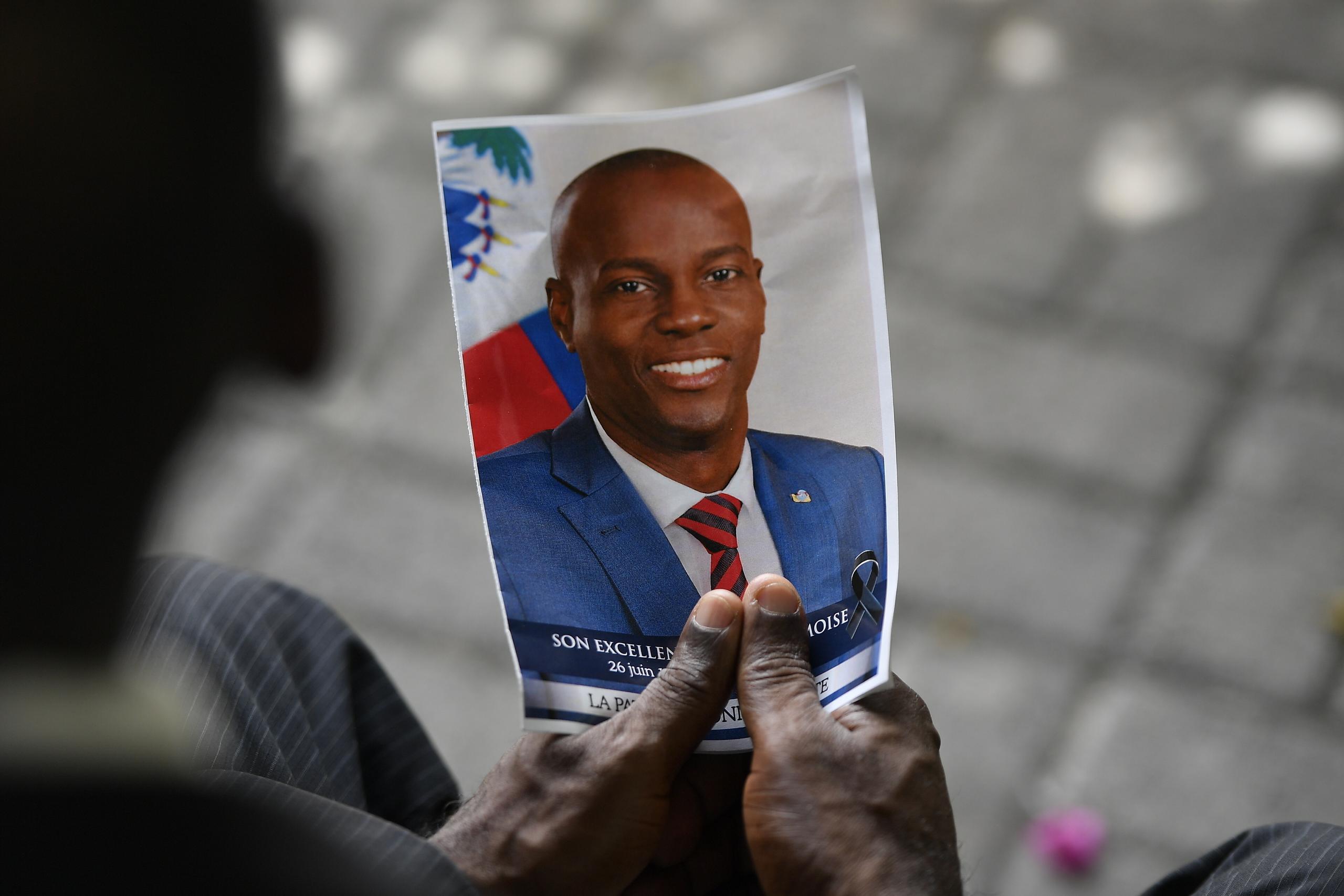 Una persona sostiene una fotografía del difunto presidente Jovenel Moïse.