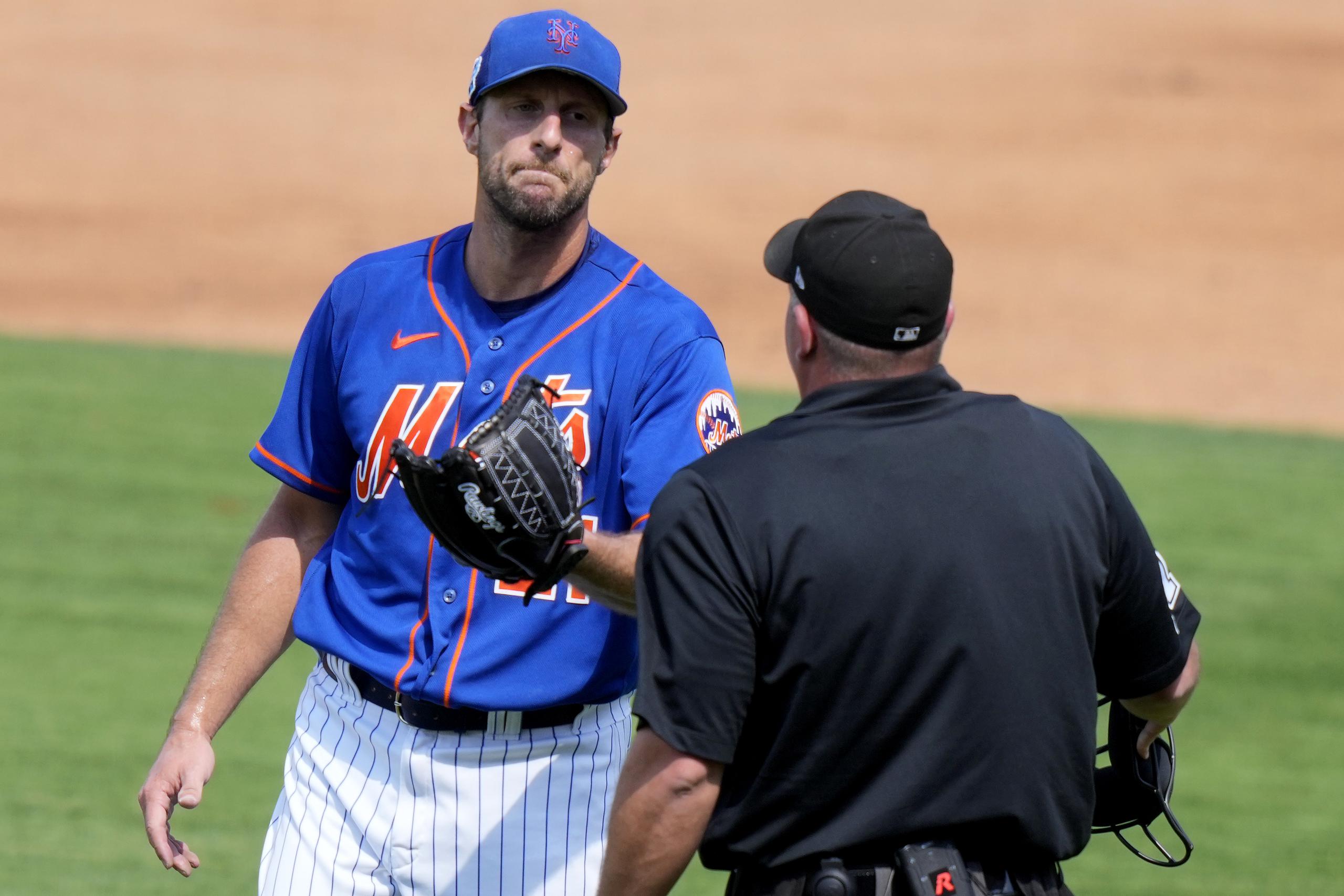 Max Scherzer, abridor de los Mets de Nueva York, habla con el umpire durante el partido de pretemporada del viernes ante los Nationals de Washington.