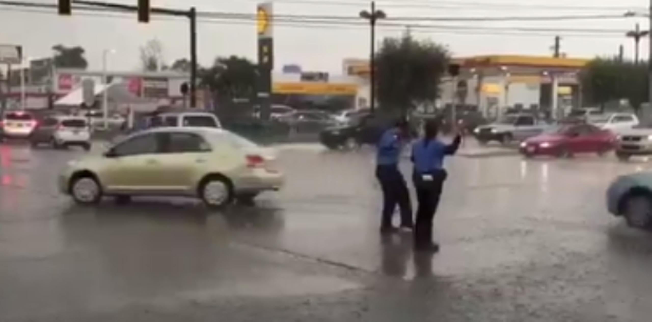 Policías ayudando en el tránsito bajo un torrencial aguacero en Caguas. (Twitter)