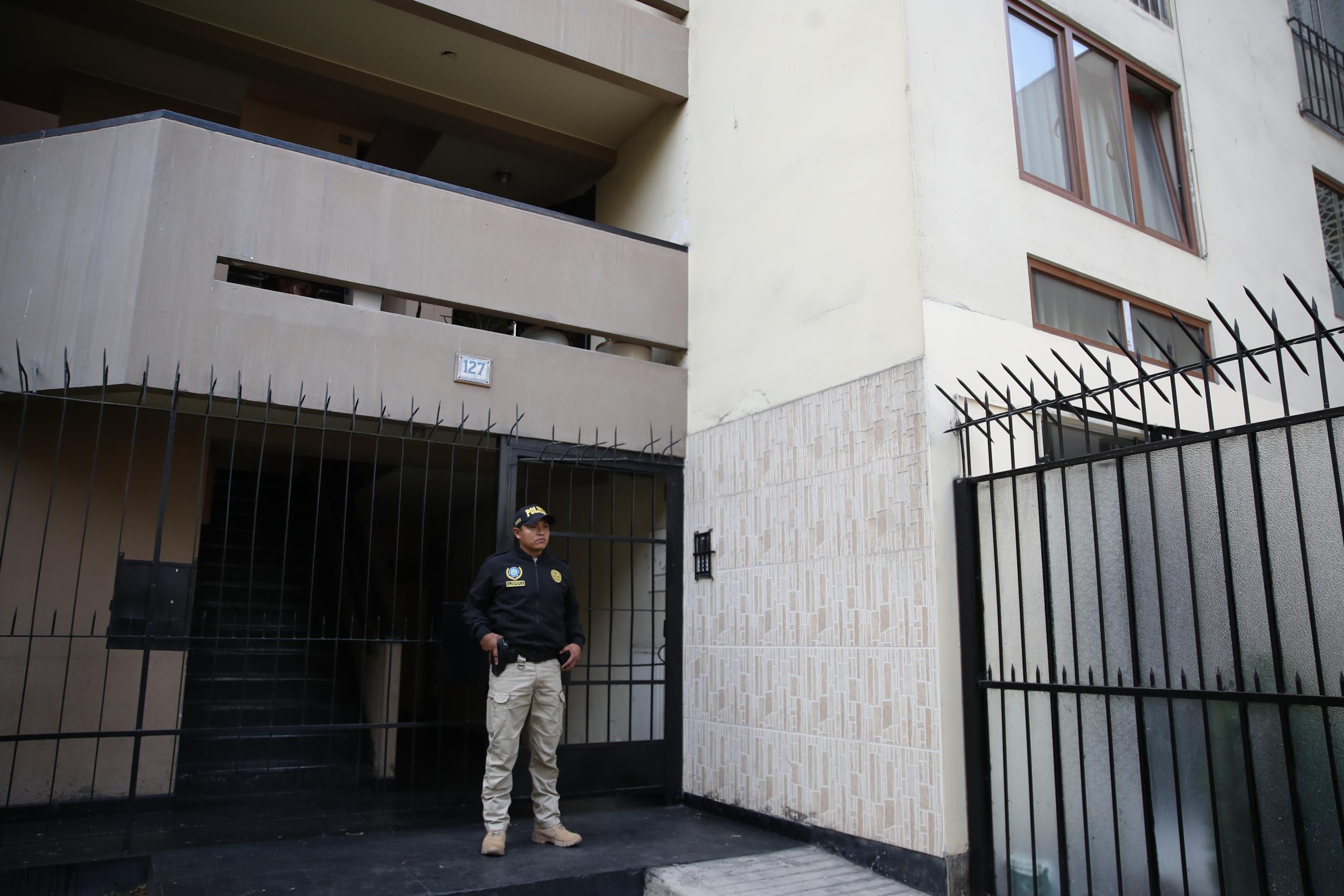 Un policía resguardando el ingreso de la vivienda de Nicanor Boluarte, hermano de la presidenta de Perú Dina Boluarte, durante el allanamiento ejecutado por la Fiscalía este viernes en Lima, en Perú. (EFE/Paolo Aguilar)