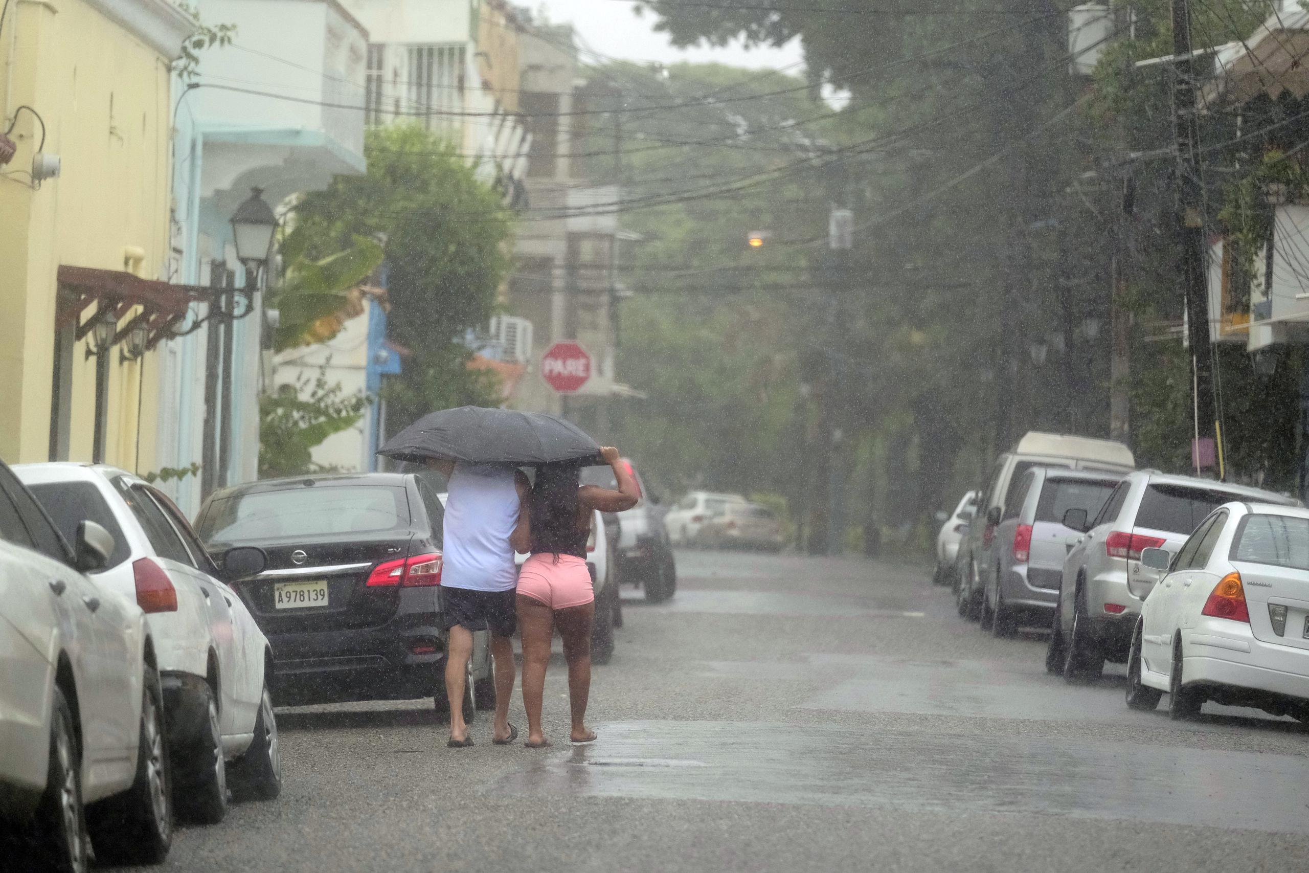 Gente camina bajo la lluvia.