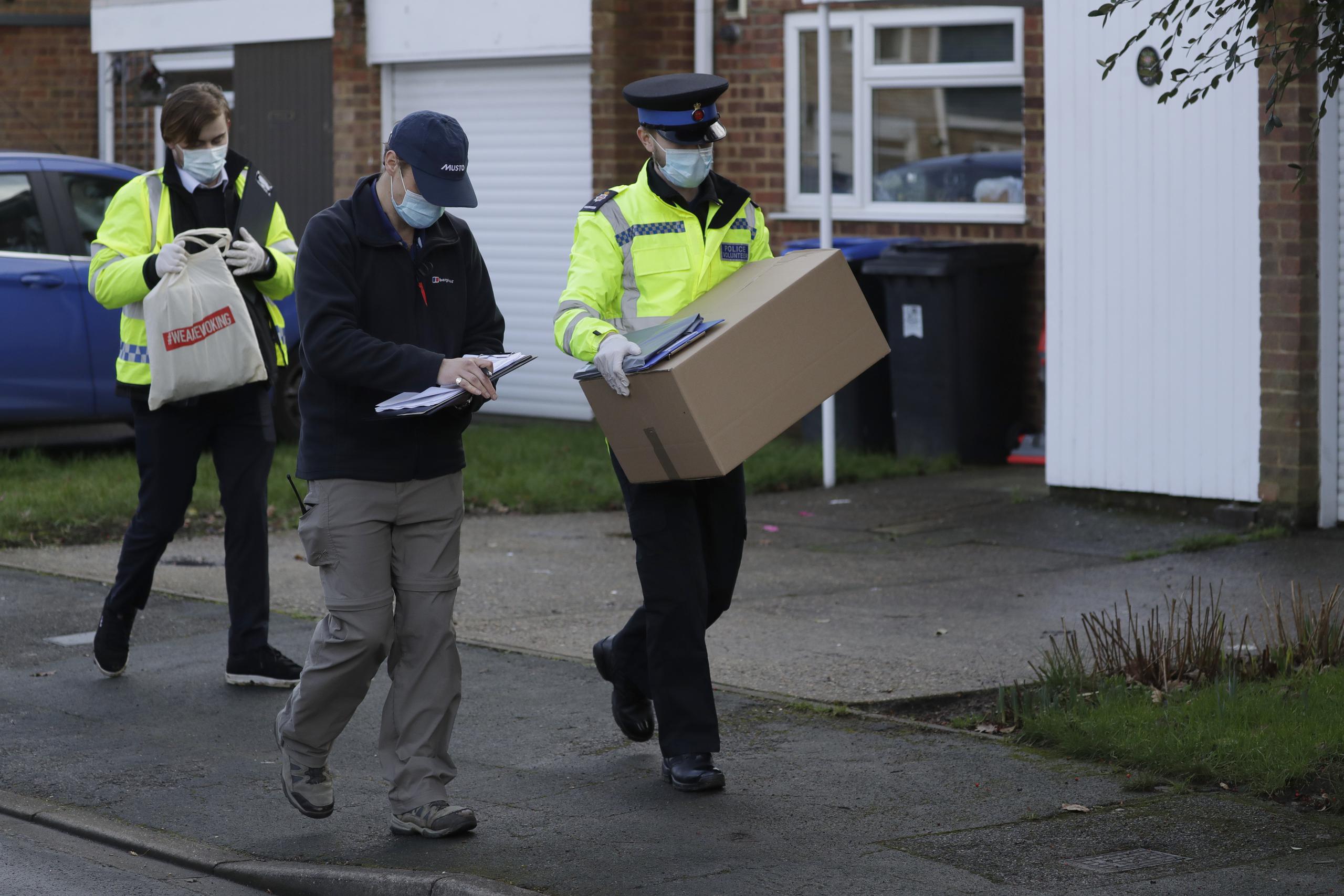 Un policía carga una caja con kits para realizar pruebas de COVID-19 en Woking, Inglaterra.