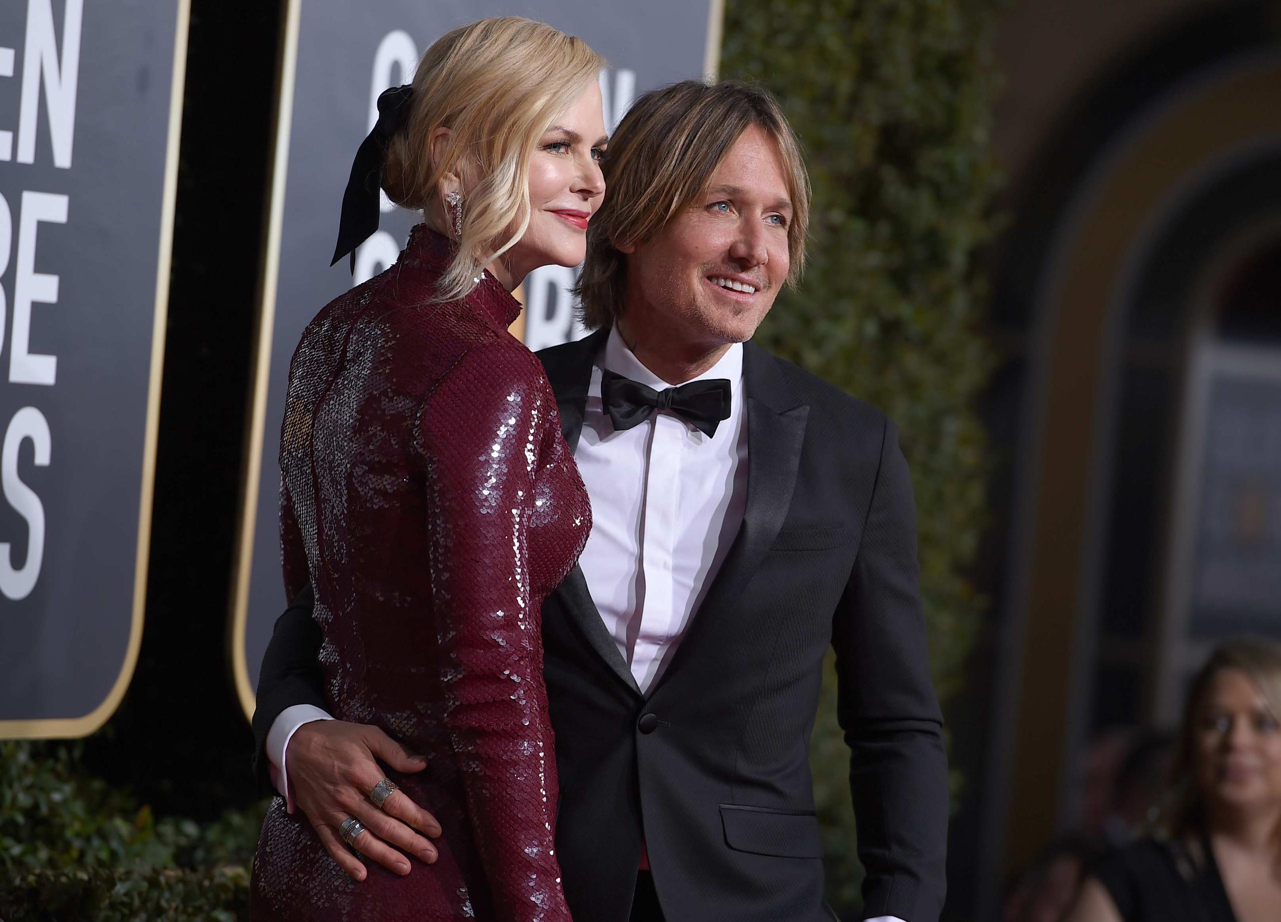La actriz Nicole Kidman abraza a su esposo el músico Keith Urban al llegar a la alfombra roja de los Golden Globe. (Foto: AP)