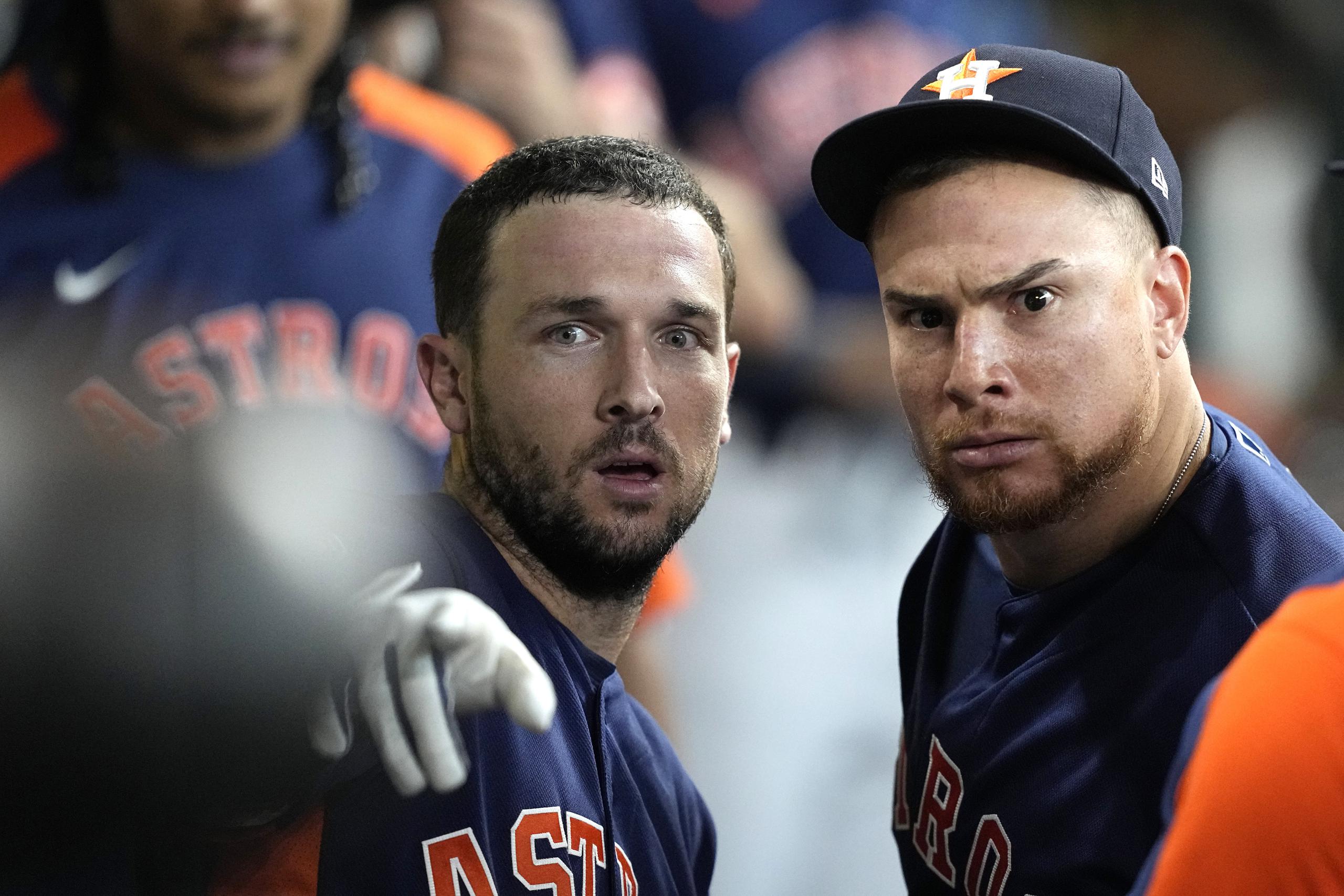 Alex Bregman y Christian Vázquez miran a la cámara en el dugout de los Astros luego de un jonrón del primero en un reciente partido.