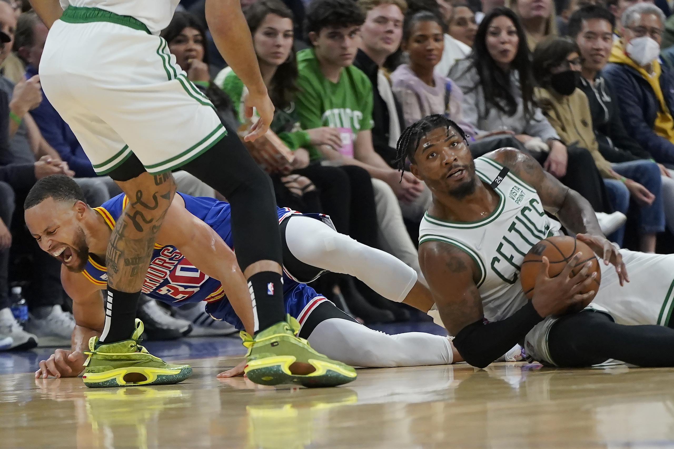 Stephen Curry, a la izquierda, suelta un grito de dolor en la jugada en la que fue tras un balón junto a Marcus Smart, de los Celtics de Boston. En la jugada Curry salió lastimado.