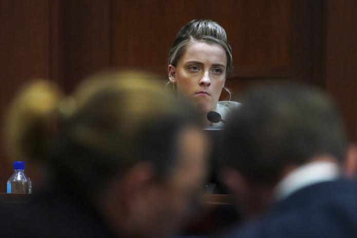 El actor Johnny Depp habla con su abogado mientras Whitney Henriquez, hermana de Amber Heard, está en el banquillo de los testigos durante el juicio en Fairfax, Virginia, el 18 de mayo de 2022.