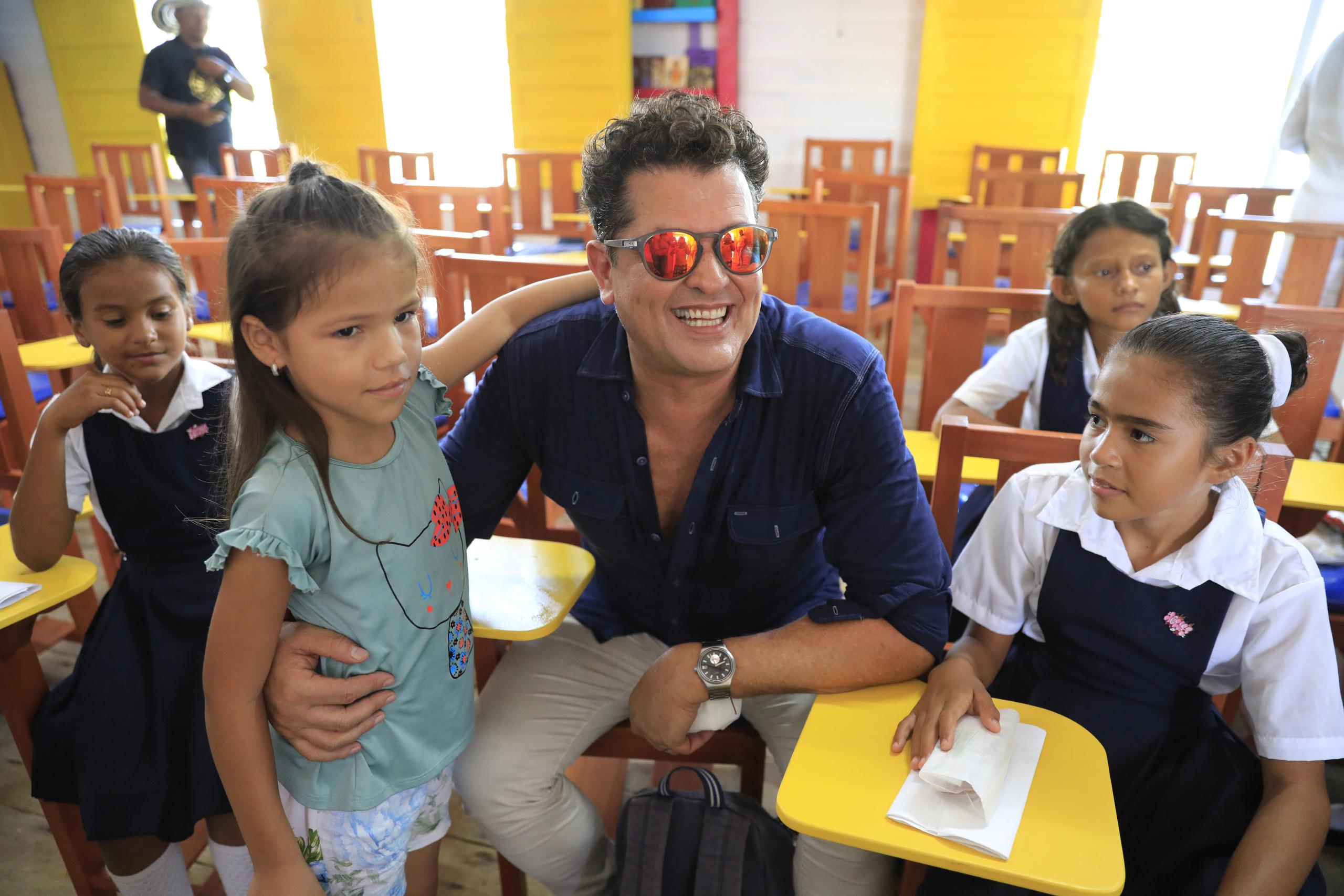 El cantante colombiano Carlos Vives posando junto a un grupo de niños en la escuela de Buena Vista, departamento de Magdalena, en Colombia. (EFE/ Carlos Ortega)