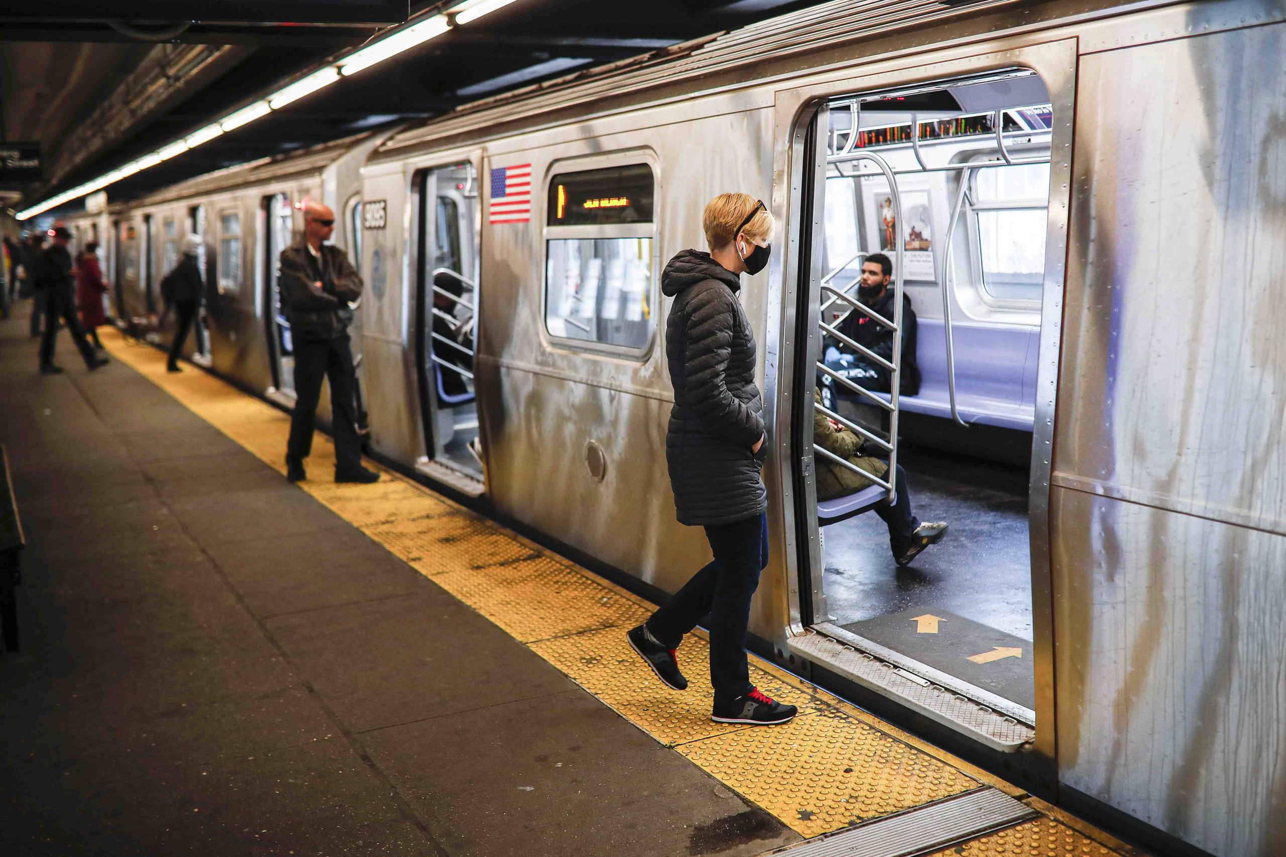Usuarios, algunos con mascarillas y guantes como medida protectora contra el coronavirus, entran a un metro en la ciudad de Nueva York. (AP)