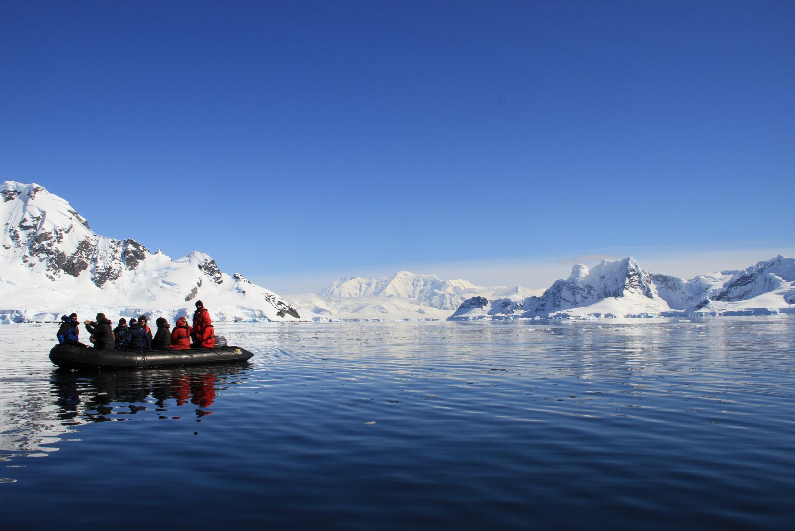 Una balsa zodiac busca un lugar para subir a la costa de Antártida.