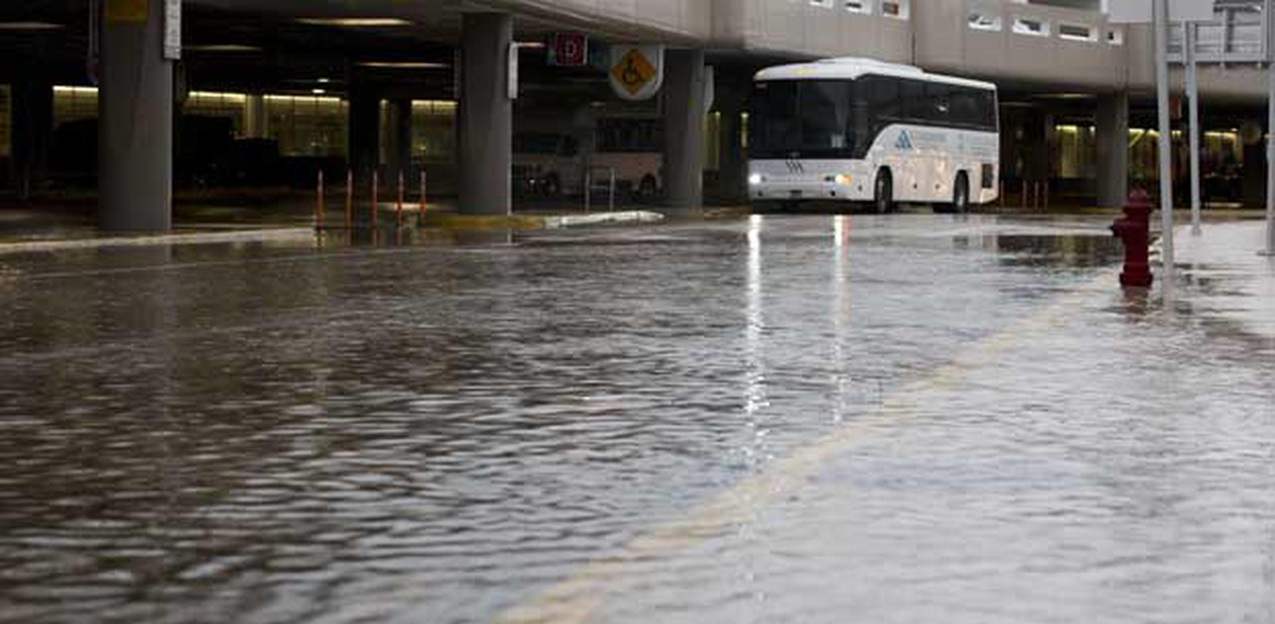 Personal del aeropuerto trabaja con un desagüe para poder sacar el agua acumulada de la zona vial del área de recogido de pasajeros. (tonito.zayas@gfrmedia.com)