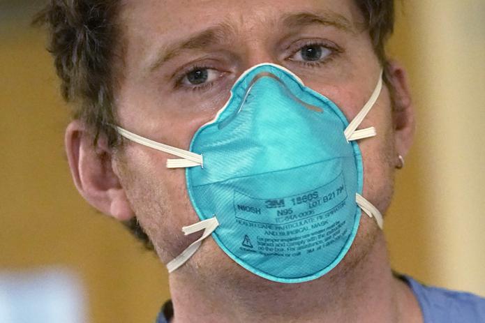 El enfermero Scott McGieson usa una mascarilla N95 mientras sale de la habitación de un paciente en la unidad de cuidados intensivos del Centro Médico Harborview, el viernes 14 de enero de 2022, en Seattle.
(Foto AP/Elaine Thompson)