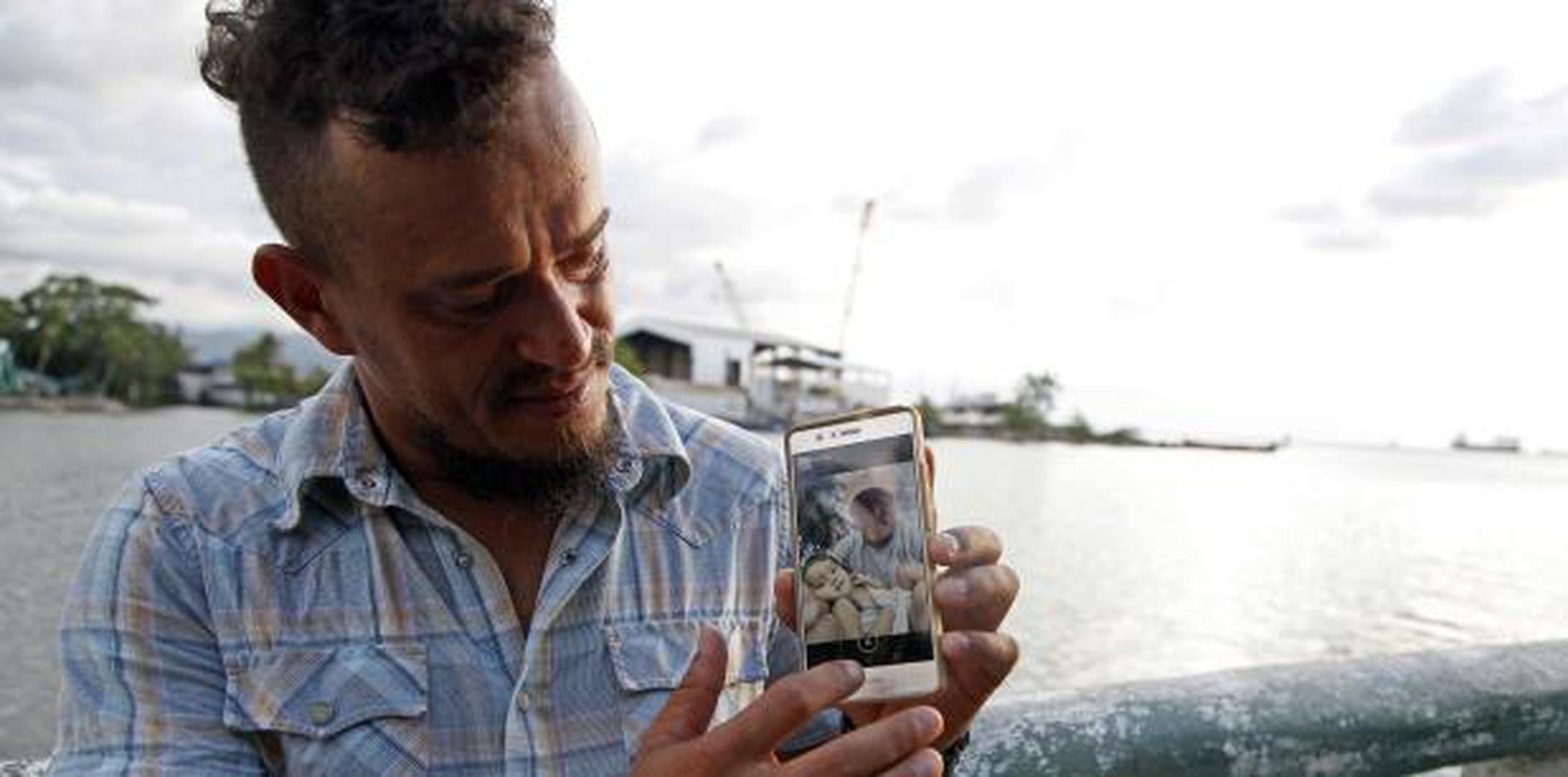 Denis Varela muestra una foto de él y su hija, la niña representada en la portada de la revista Time, durante una entrevista en Puerto Cortés, Honduras, ayer, viernes. (AP / Fernando Antonio)