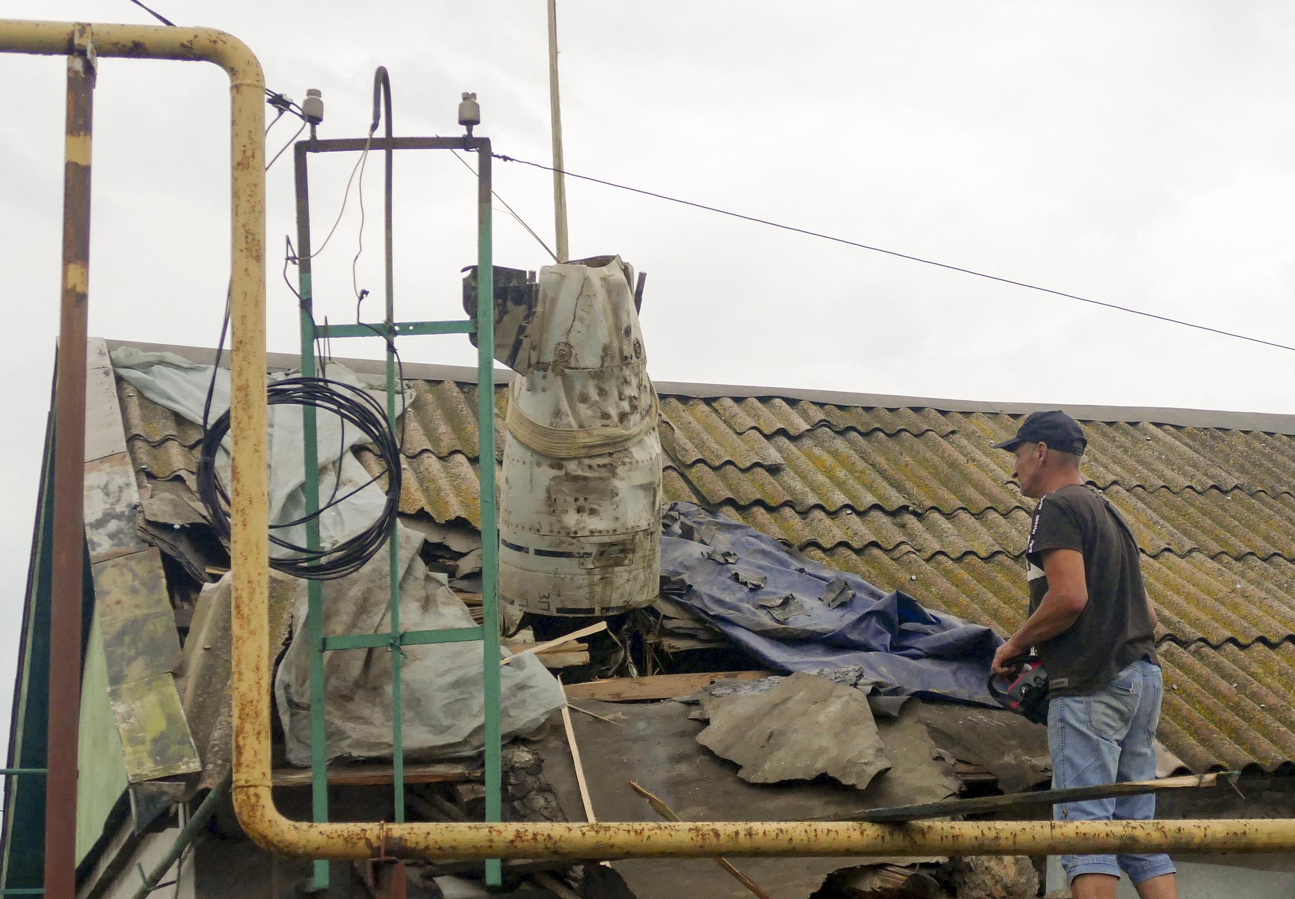 Un trabajador extrae una parte de un cohete del tejado de un edificio en Odesa, en el sur de Ucrania, el 18 de julio de 2023. (EFE/EPA/IGOR TKACHENKO)