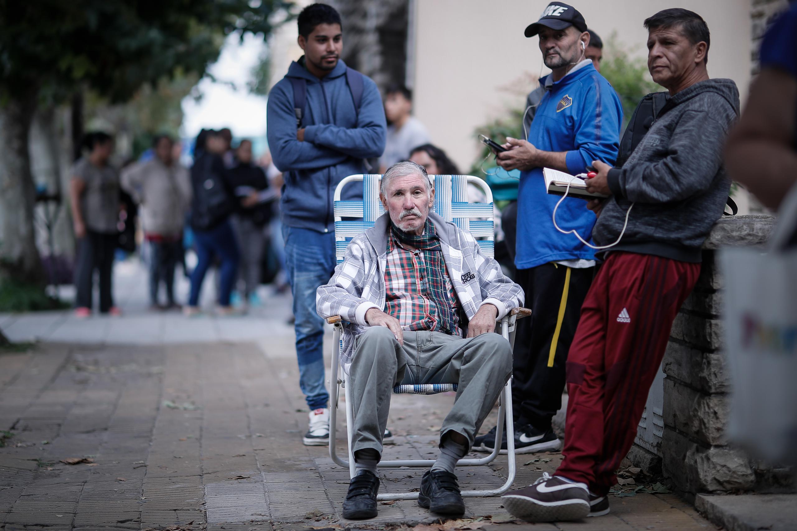 Adultos mayores esperan en fila para poder cobrar su jubilación, este viernes, en un Banco de San Justo, en la provincia de Buenos Aires (Argentina).