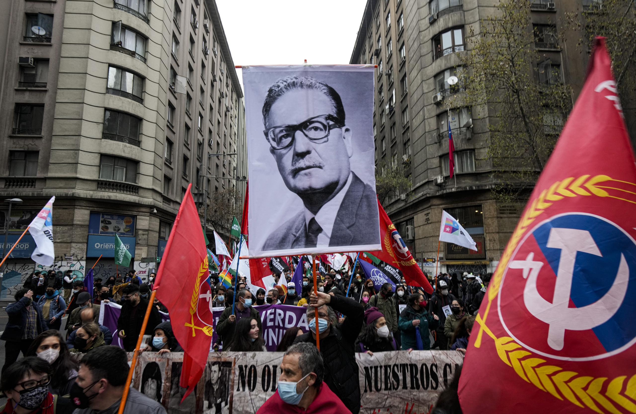 Un manifestante sostiene una fotografía del presidente chileno finado Salvador Allende durante las protestas por el 48vo aniversario del golpe militar de 1973 y su muerte subsecuente, en Santiago, Chile.