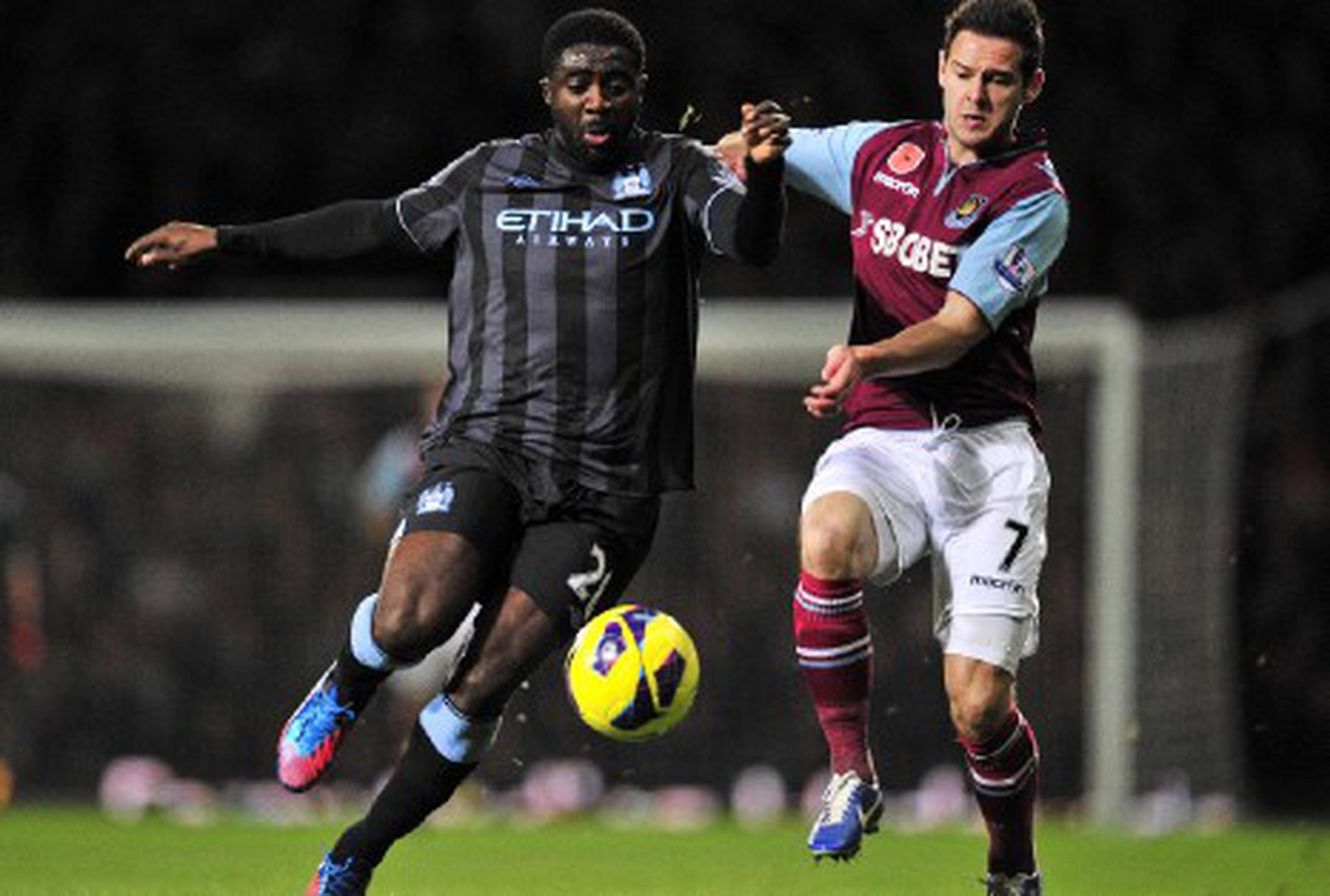 El defensa del Manchester City, Kolo Toure, izq., lucha por la posesión de balón con Matt Jarvis del West Ham. (AFP / Glyn Kirk)