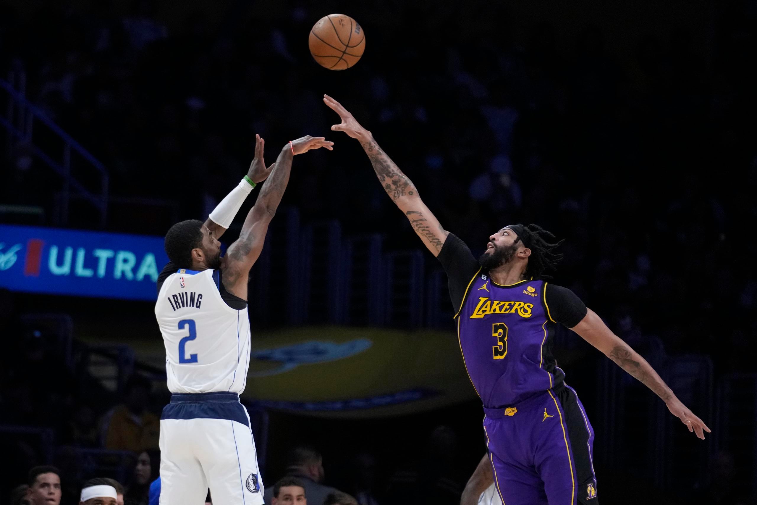 El jugador de los Mavericks de Dallas Kyrie Irving (2) lanza un triple ante Anthony Davis (3), de los Lakers de Los Ángeles.