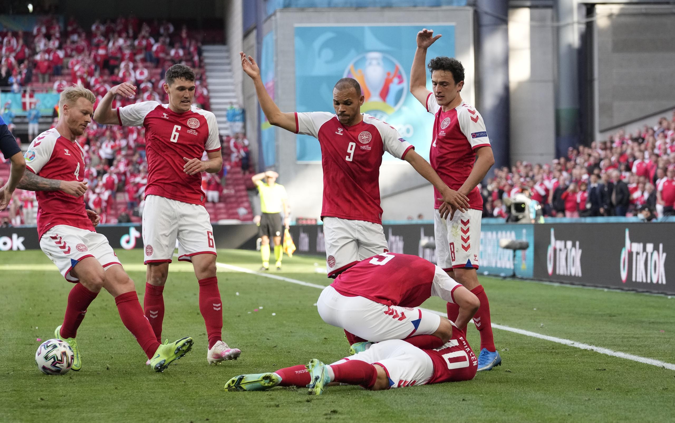 Jugadores de Dinamarca solicitan atención médica para su compañero Christian Eriksen, quien se desvaneció durante el partido de la Eurocopa ante Finlandia.