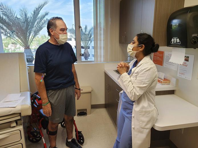 Arthur Sánchez, de 52 años, conversa con la doctora Aswini Arjuna como parte del seguimiento a su operación, en Phoenix, Arizona.