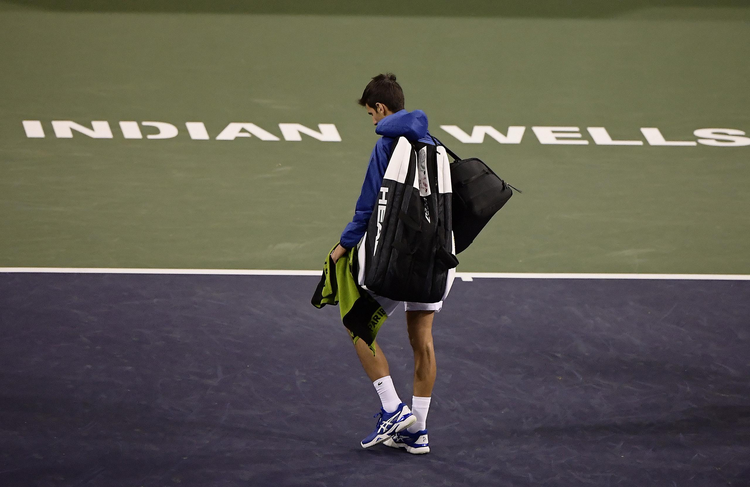 El tenista número uno del mundo, el serbio Novak Djokovic, sale de la cancha cuando fue detenido por lluvia un juego contra el alelmán Philipp Kohlschreiber, el miércoles en el BNP Paribas Open en Indian Wells, California. El torneo fue pospuesto.