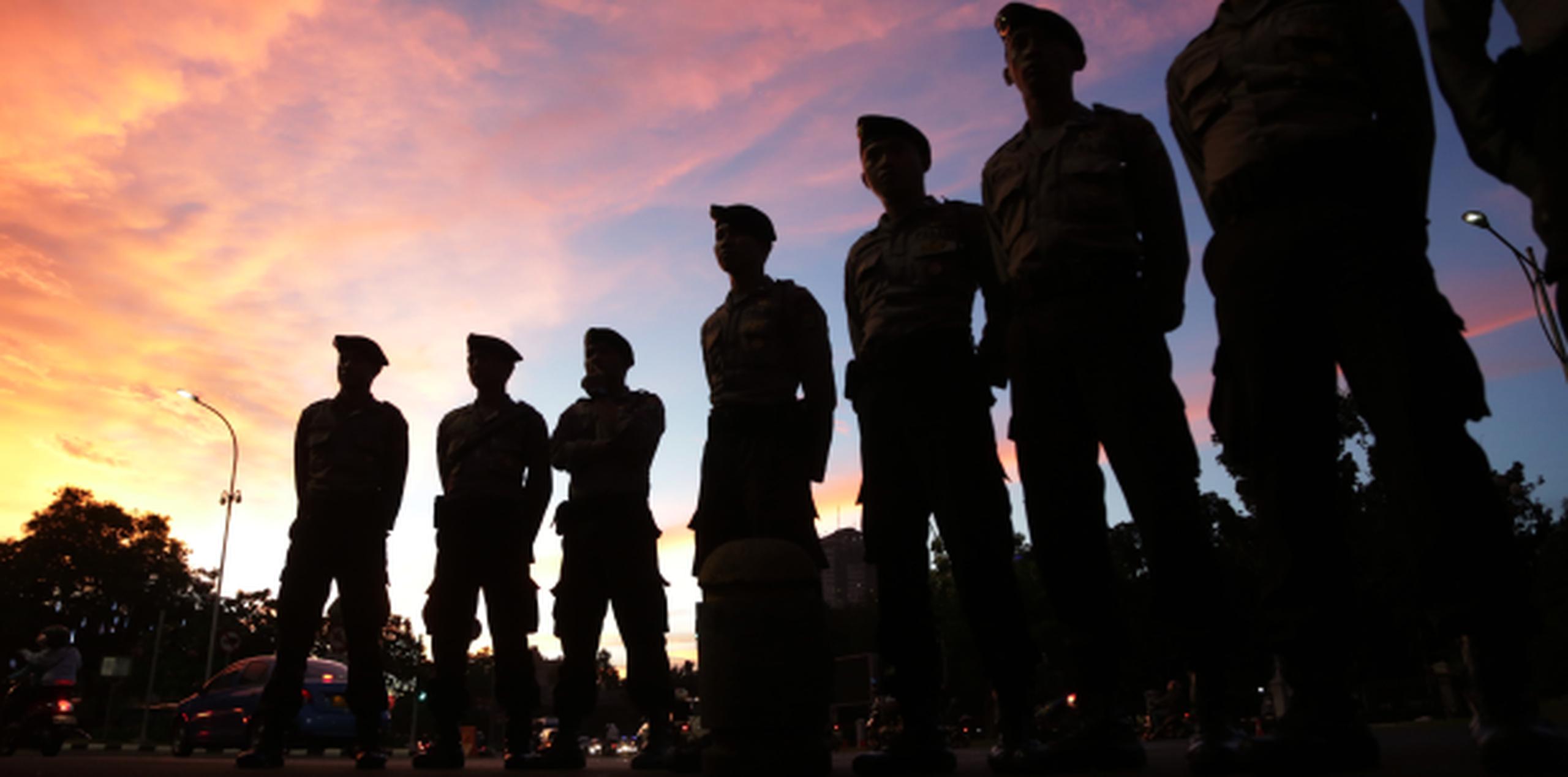 Policías vigilan manifestantes en contra de la ejecución de reos en Indonesia. (AP)