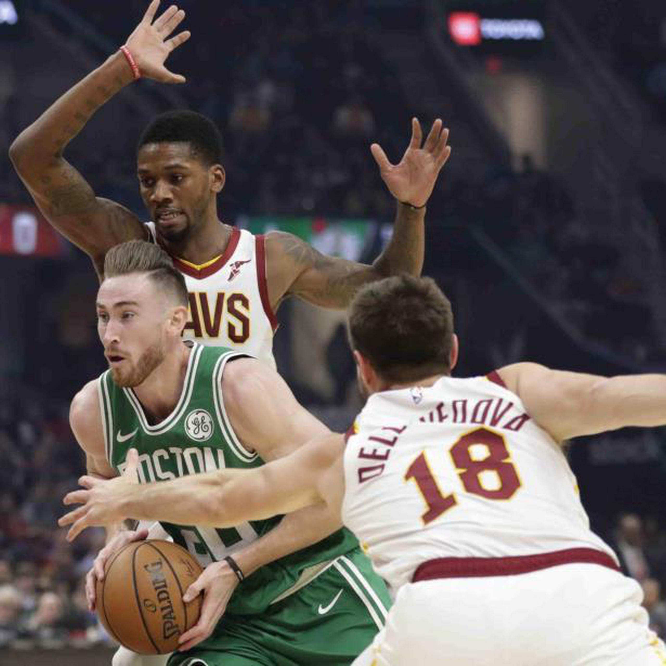 Gordon Hayward, de los Celtics de Boston, se desplaza entre Matthew Dellavedova (18) y Alfonso  McKinnie, de los Cavaliers de Cleveland, durante la primera mitad del encuentro del martes. (AP / Tony Dejak)